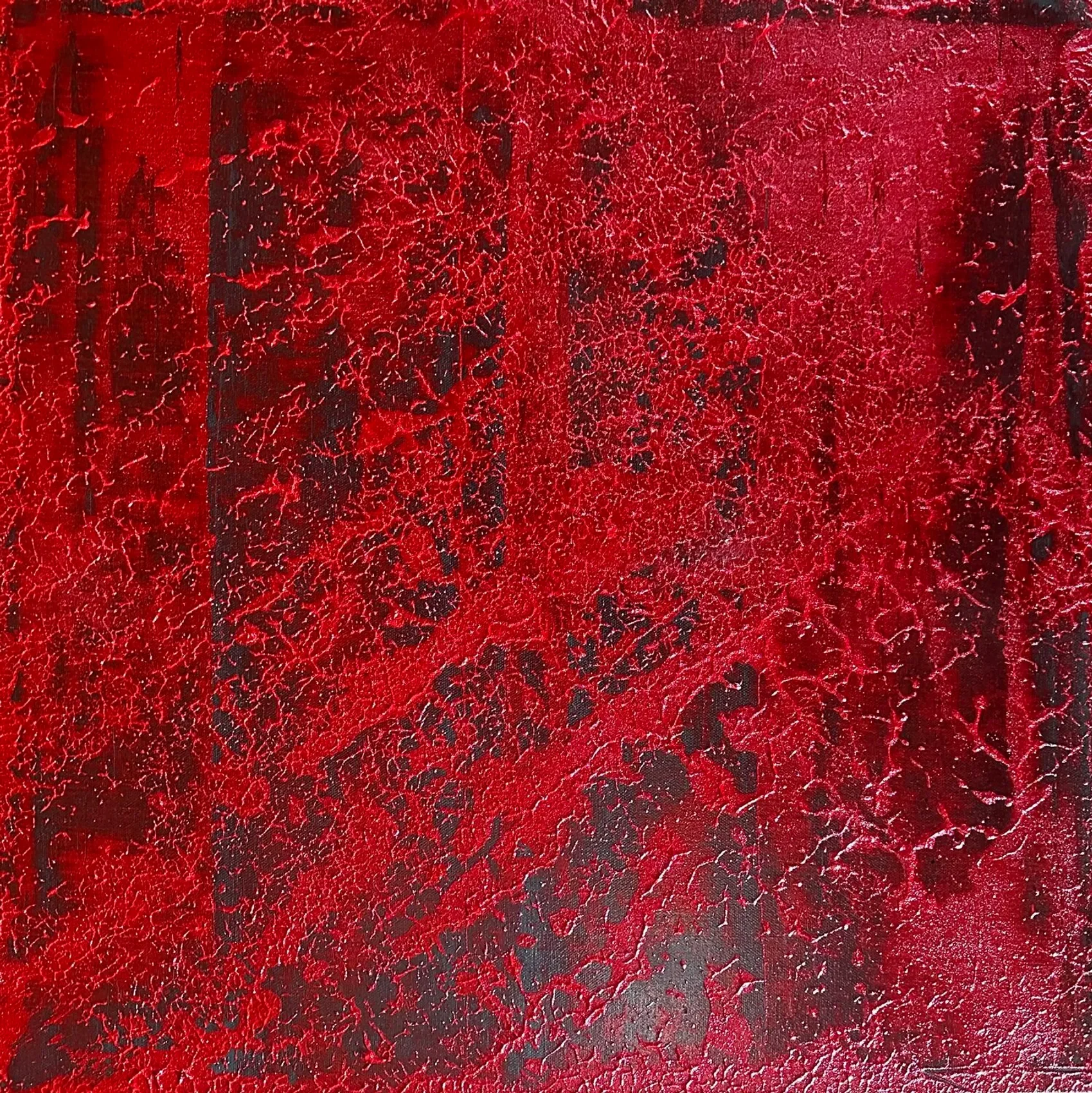 A close-up of a red textured surface with black markings and cracks.