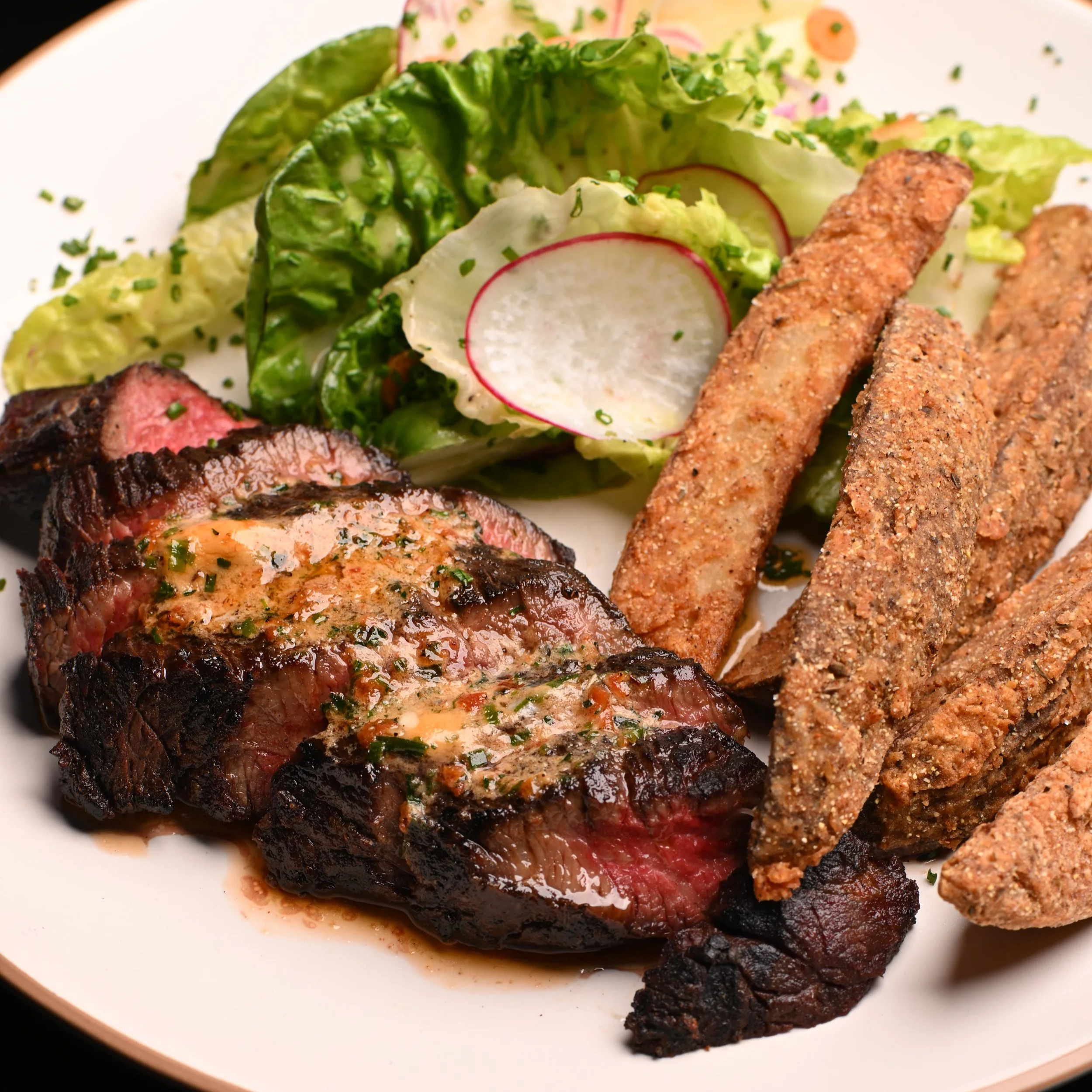 Thai Wagyu Bavette and fried "jo jo" Potato Wedges. Steak frites American-style side salad. American food, bar and grill style.