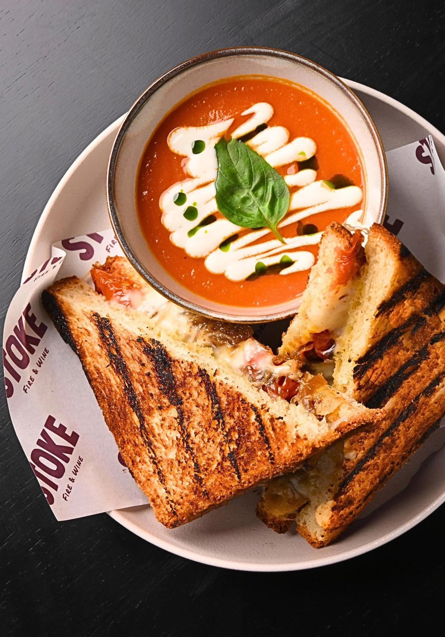 Our Really Grilled Cheese is pressed and grilled over charcoal, served with tomato soup &amp; lime crema. The kind of lunch that just works 🔥😉
#stokebangkok