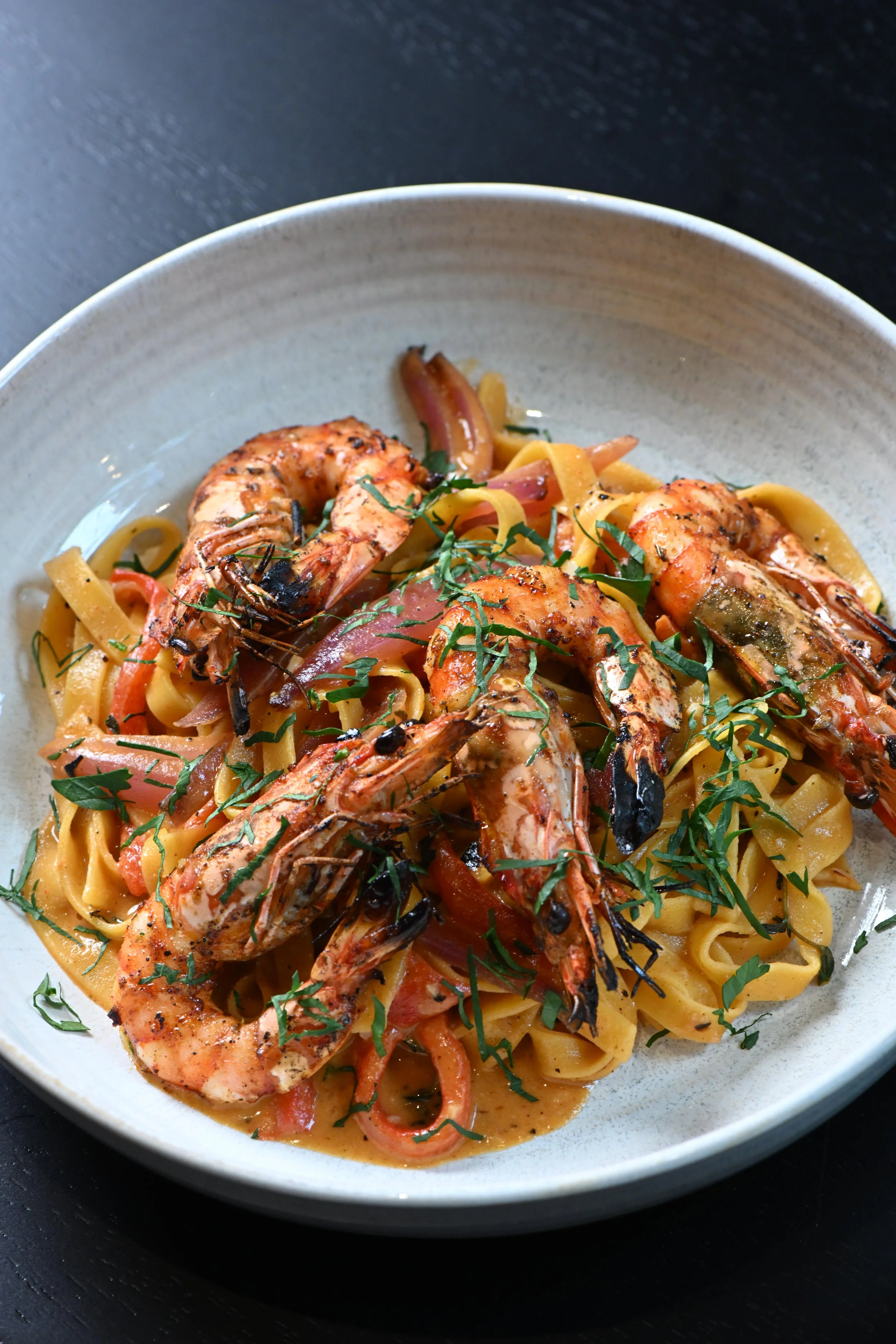 Cajun Prawn Pasta
Hand-rolled fettuccini in spicy cajun sauce with tiger prawns and charcoal grilled peppers and onion. Fresh pasta. 