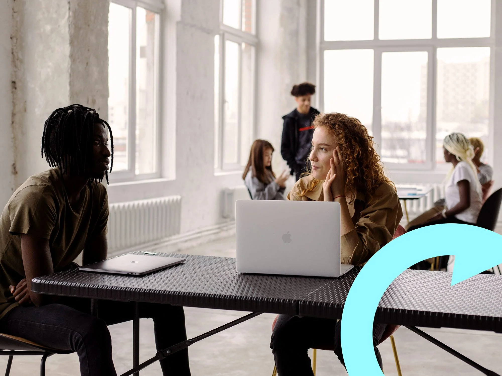 Two people sat, one mentoring the other.