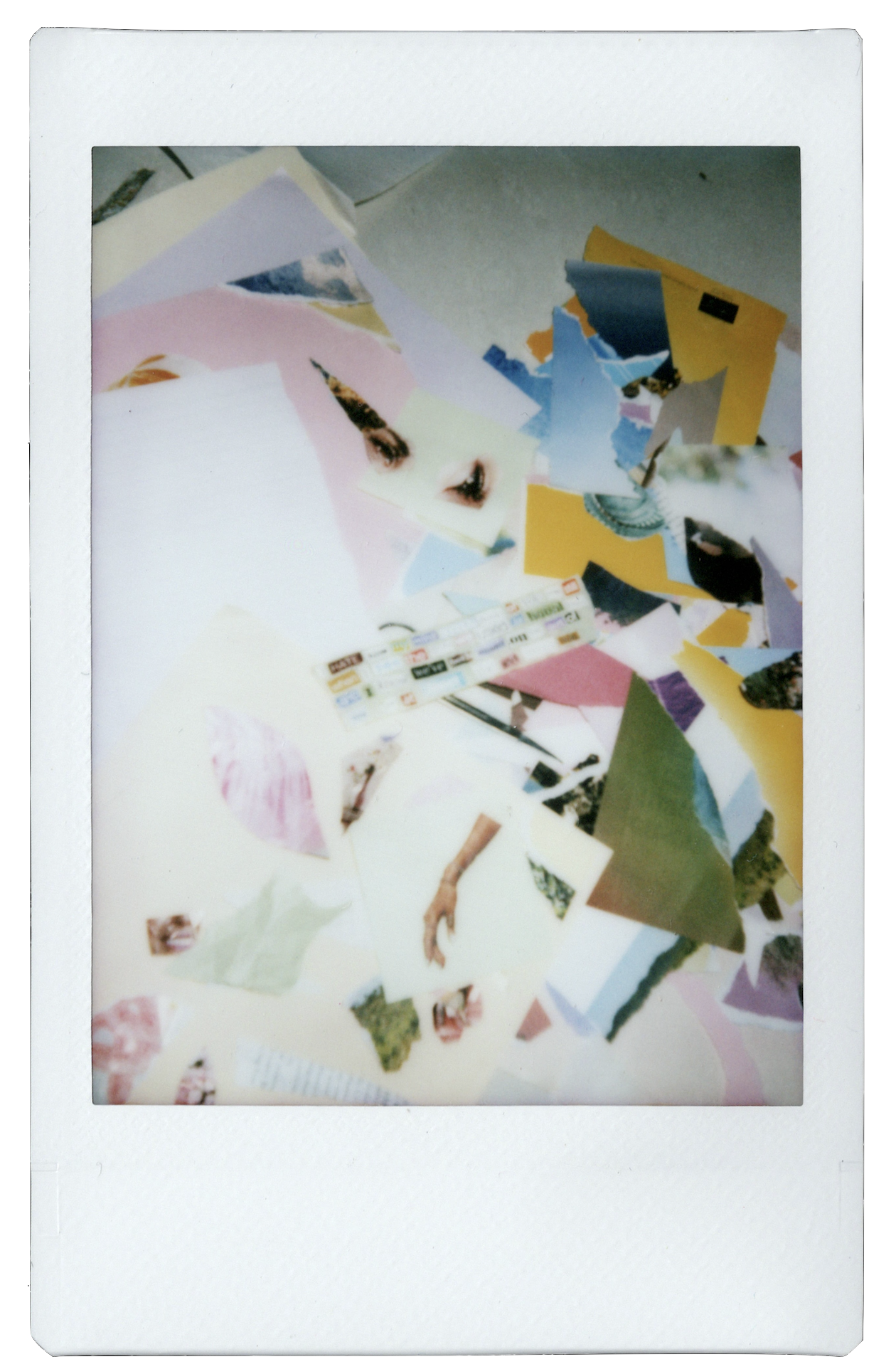 a polaroid documenting the creation of the 'Stranger Every Day' lyric video. Cut out elements and words from magazines and torn papers litter the floor.