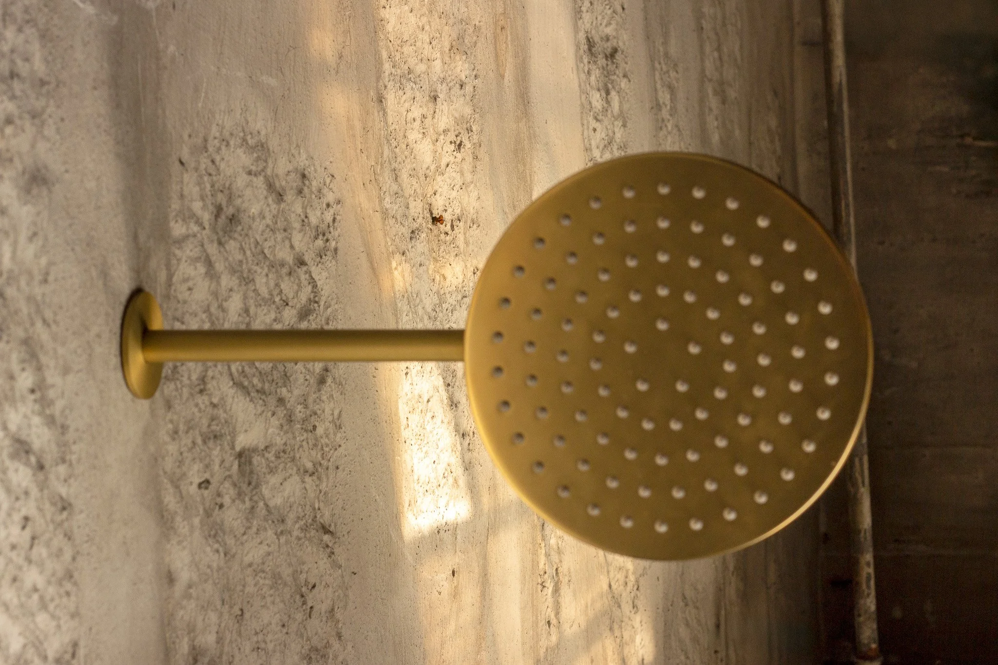 Imagem de uma decoração com uma mesa de pedra cinza e um projeto de iluminação indireta. Há uma cadeira azul escura ao fundo.