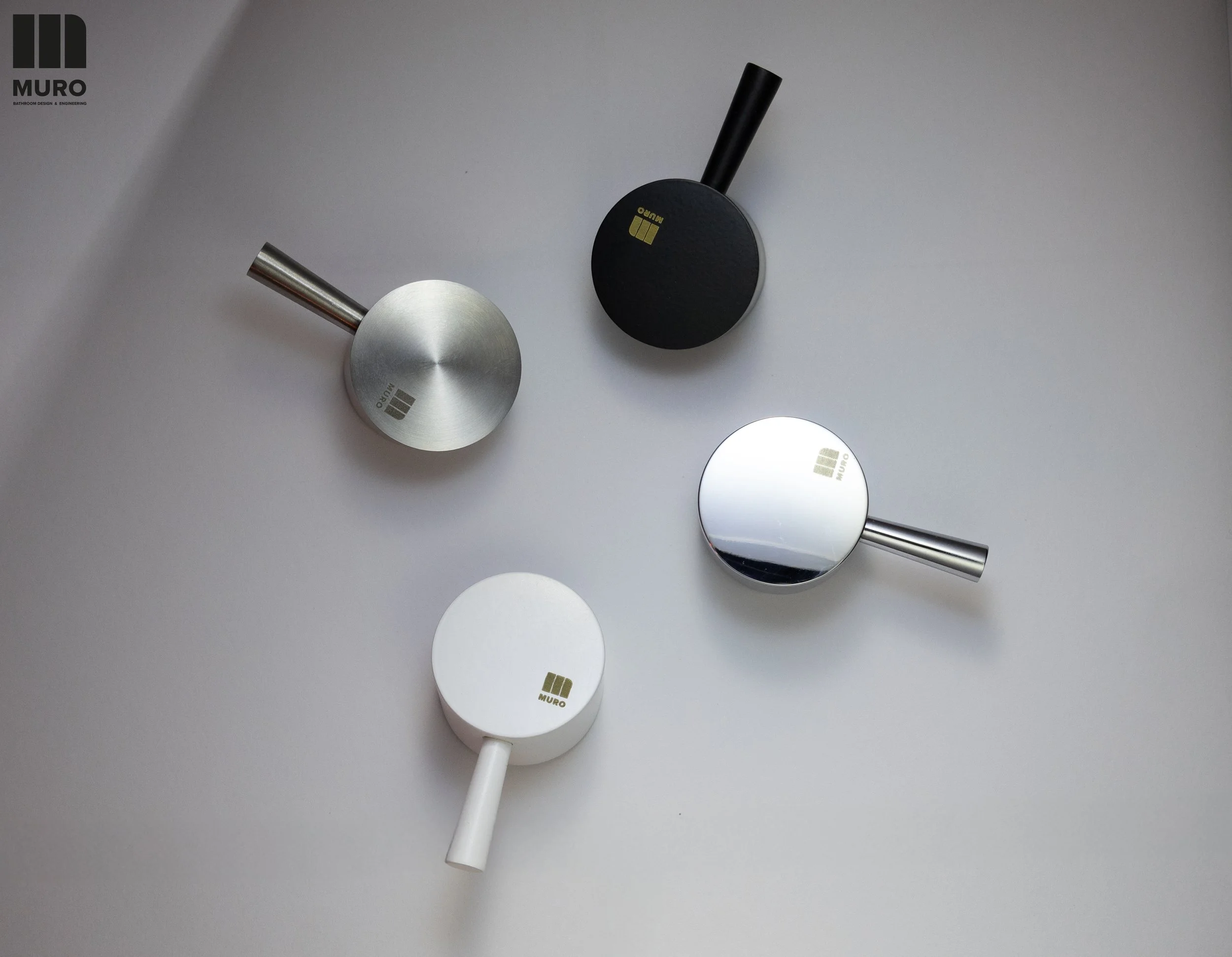 Luminária de parede de design moderno com acabamento em metal preto e prata, marcada com a marca MURO, colocada em uma parede clara