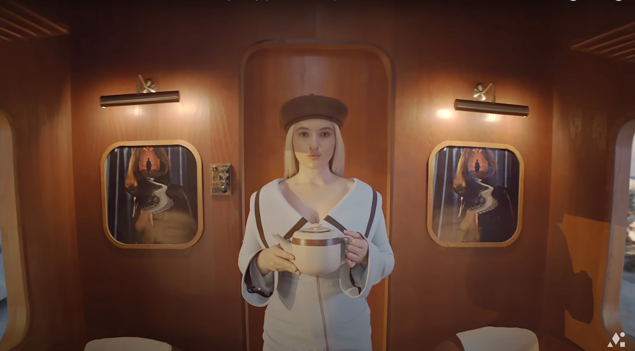A woman with long blonde hair, wearing a white uniform and a brown hat, holding a bowl and spoon inside a vintage wooden train compartment with two side windows reflecting her image.