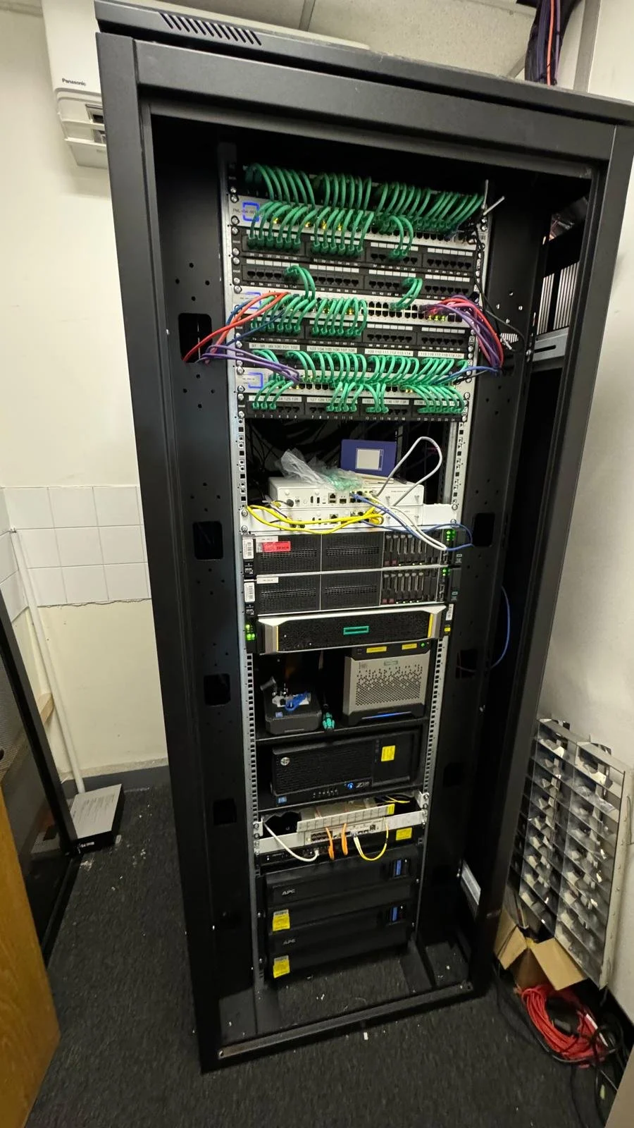 Server rack with network equipment, cables, and storage devices.