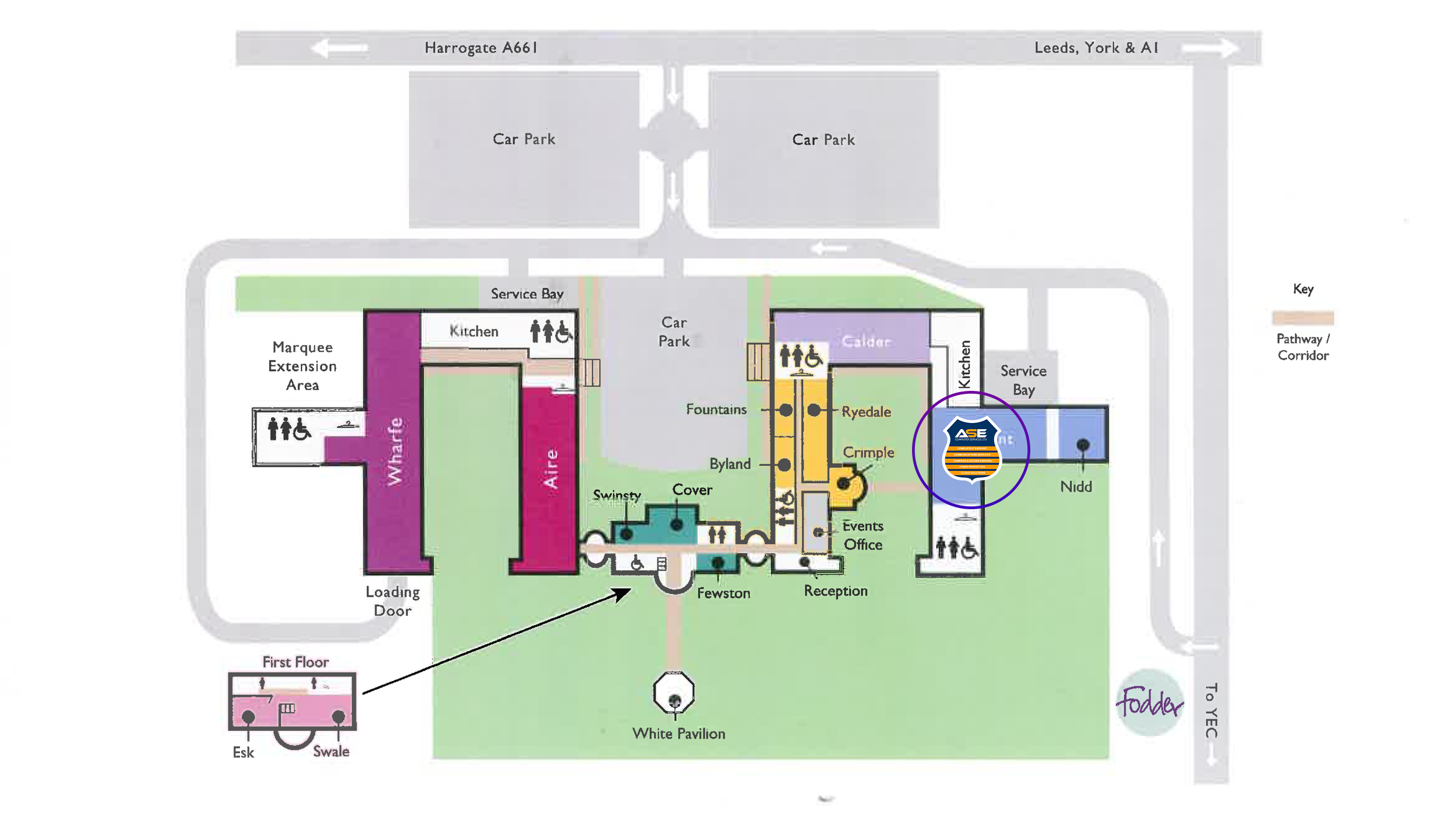 A detailed map of a facility layout showing parking areas, pathways, key features such as the White Pavilion, turf fields, and various buildings including kitchens, toilets, and an events office. It also highlights a specific location with a circular ASE logo.