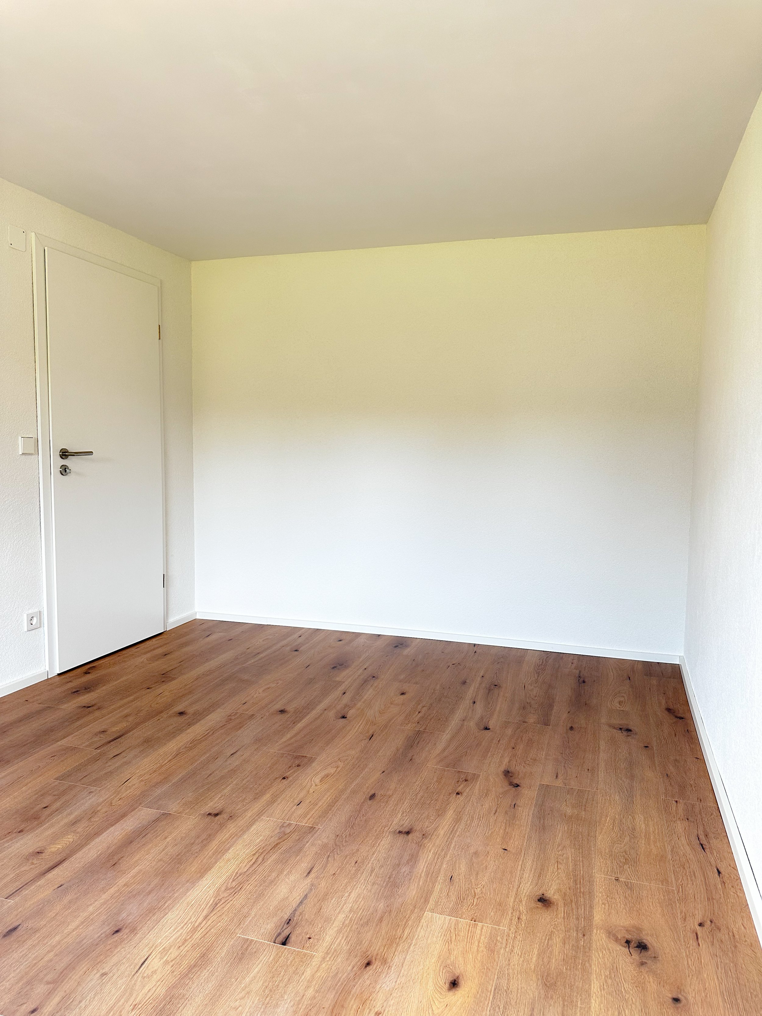 Saniertes Zimmer mit Laminat und verputzten Wänden