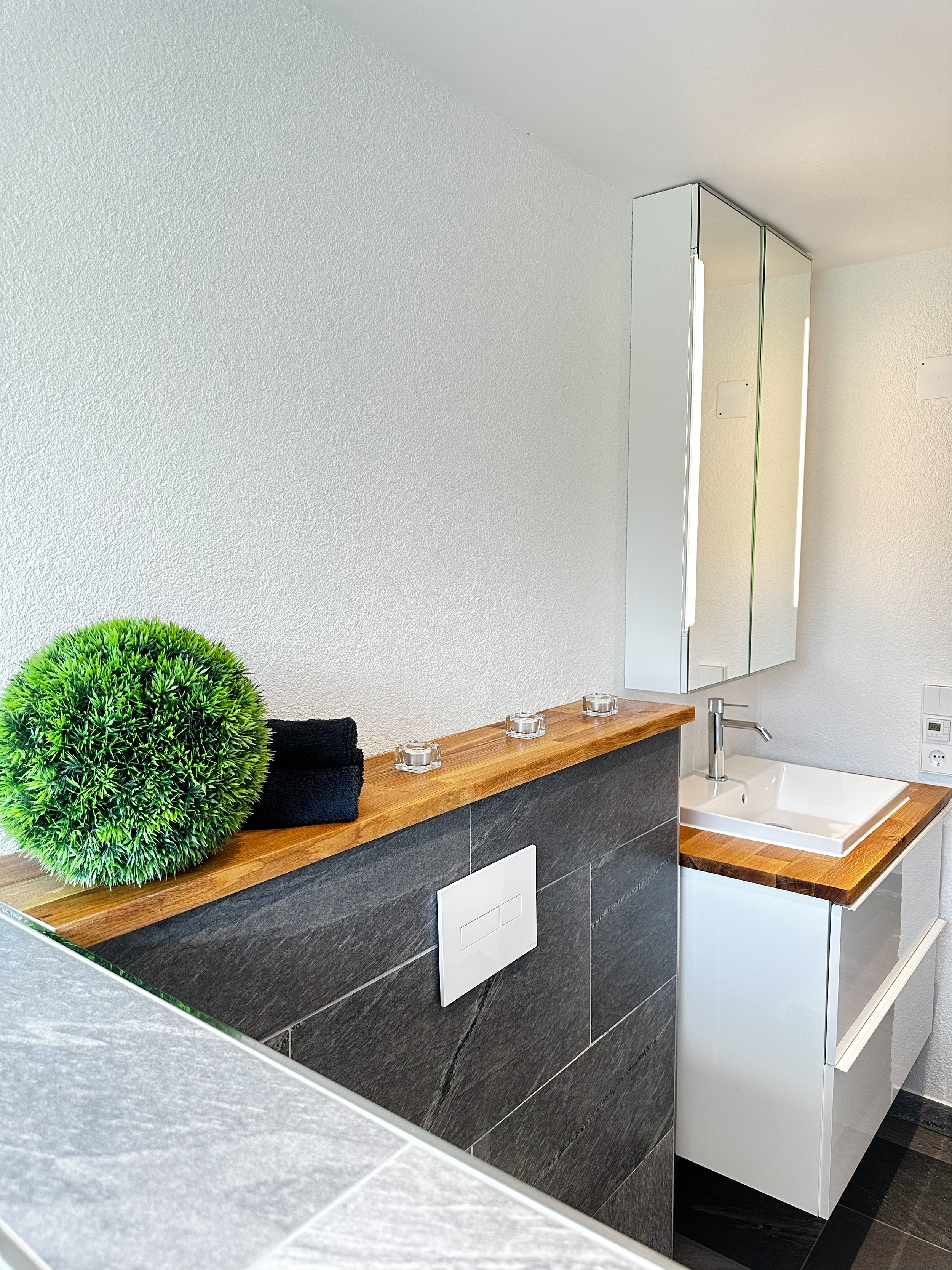 Kernsaniertes Badezimmmer mit großformatigen Fließen und begehbarer Dusche