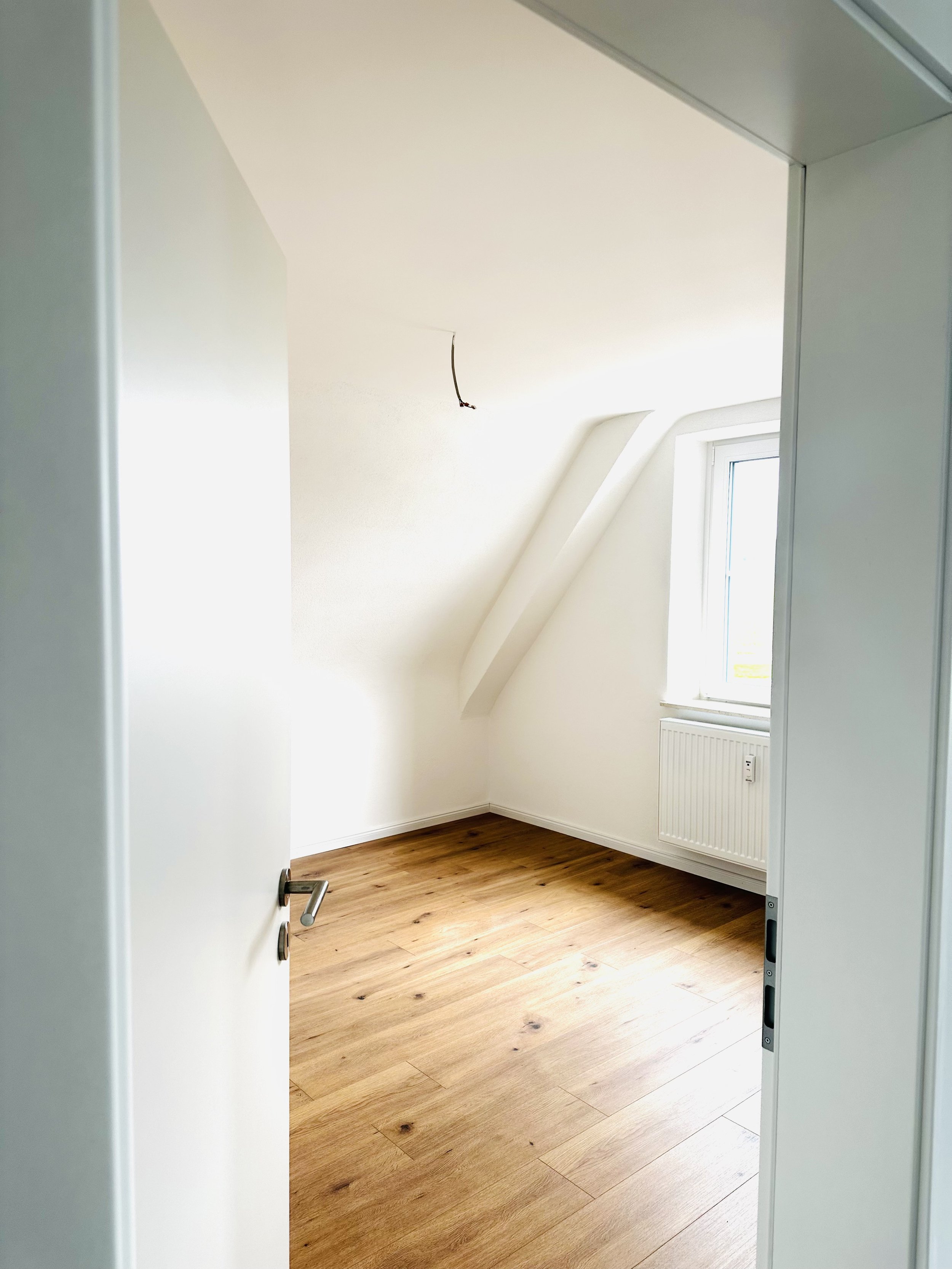 Helles Schlafzimmer mit verputzten Wänden und Eichen Laminat