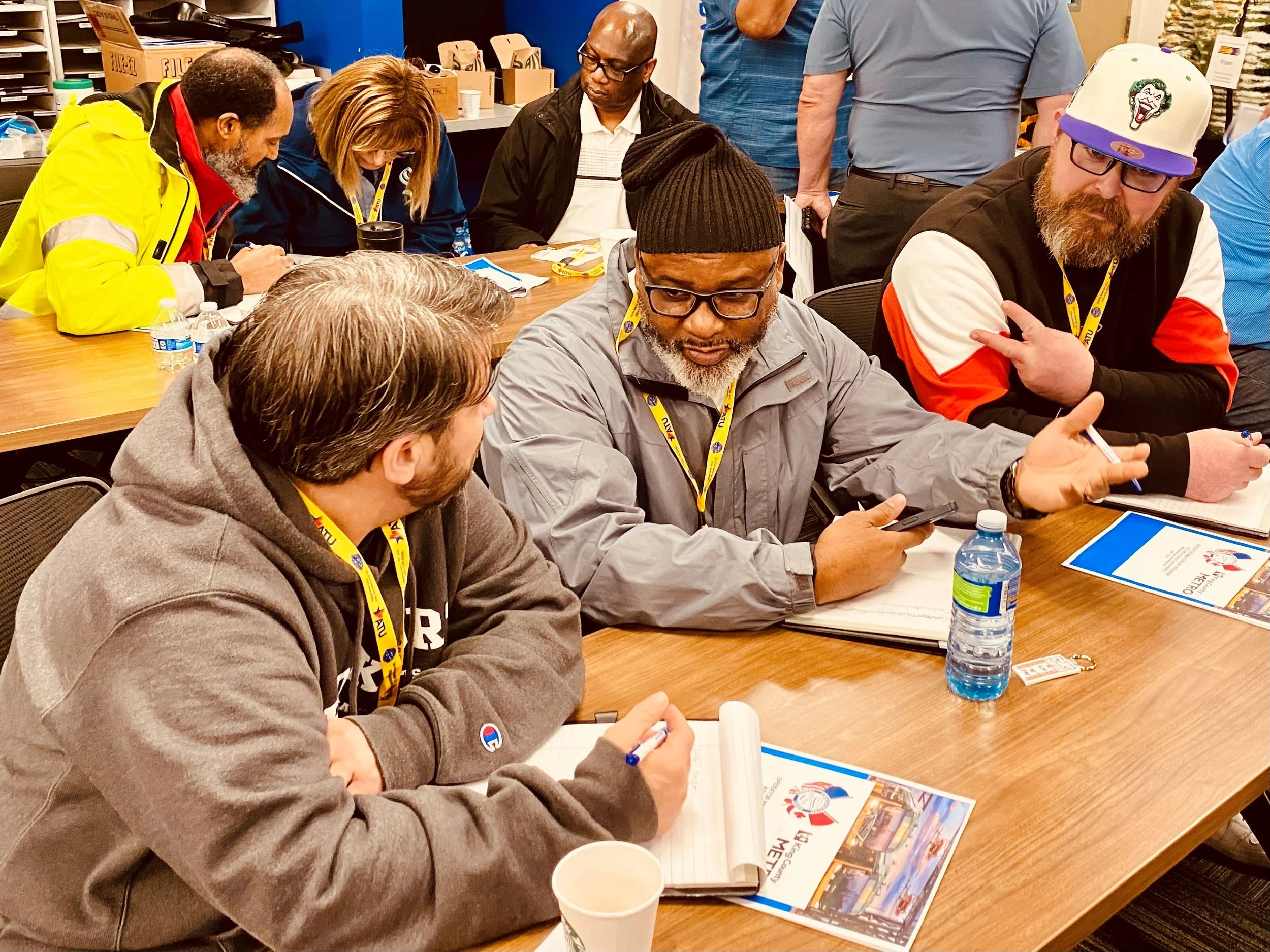 Transit union members talk with each other at a meeting.