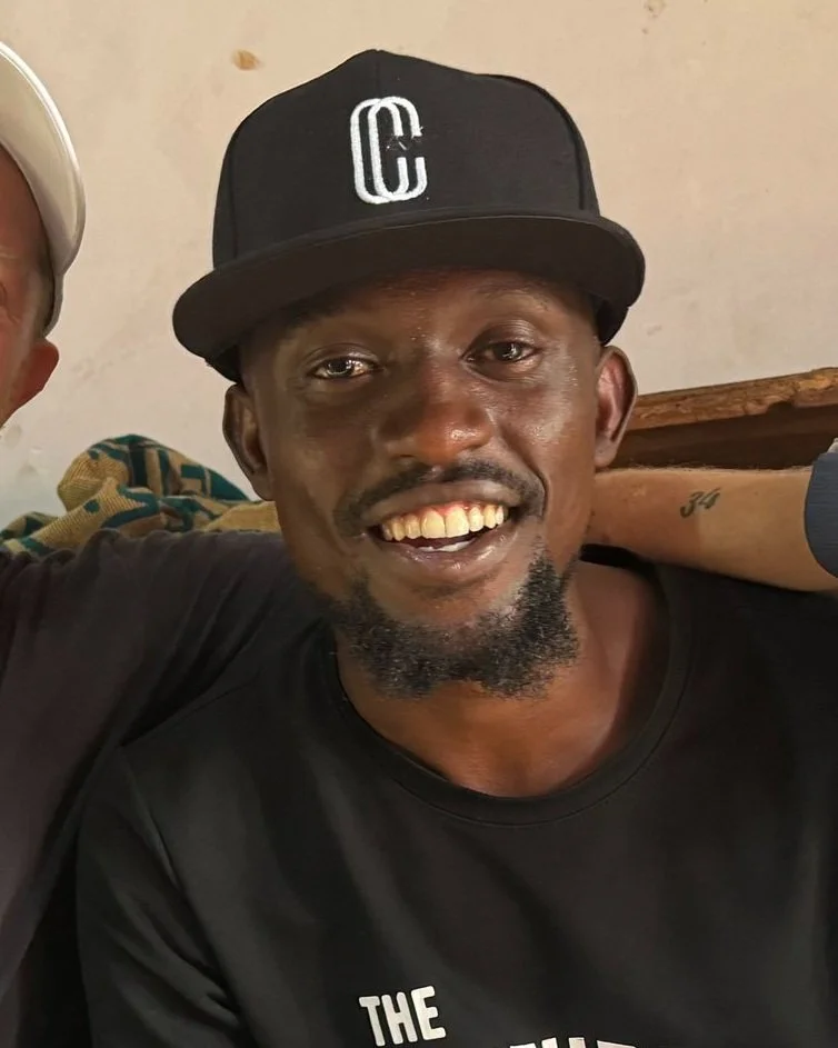 Smiling man wearing a black baseball cap and black T-shirt