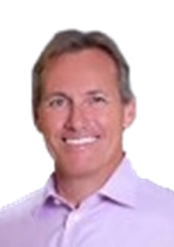 Portrait of a smiling man with short gray hair, wearing a light purple collared shirt.