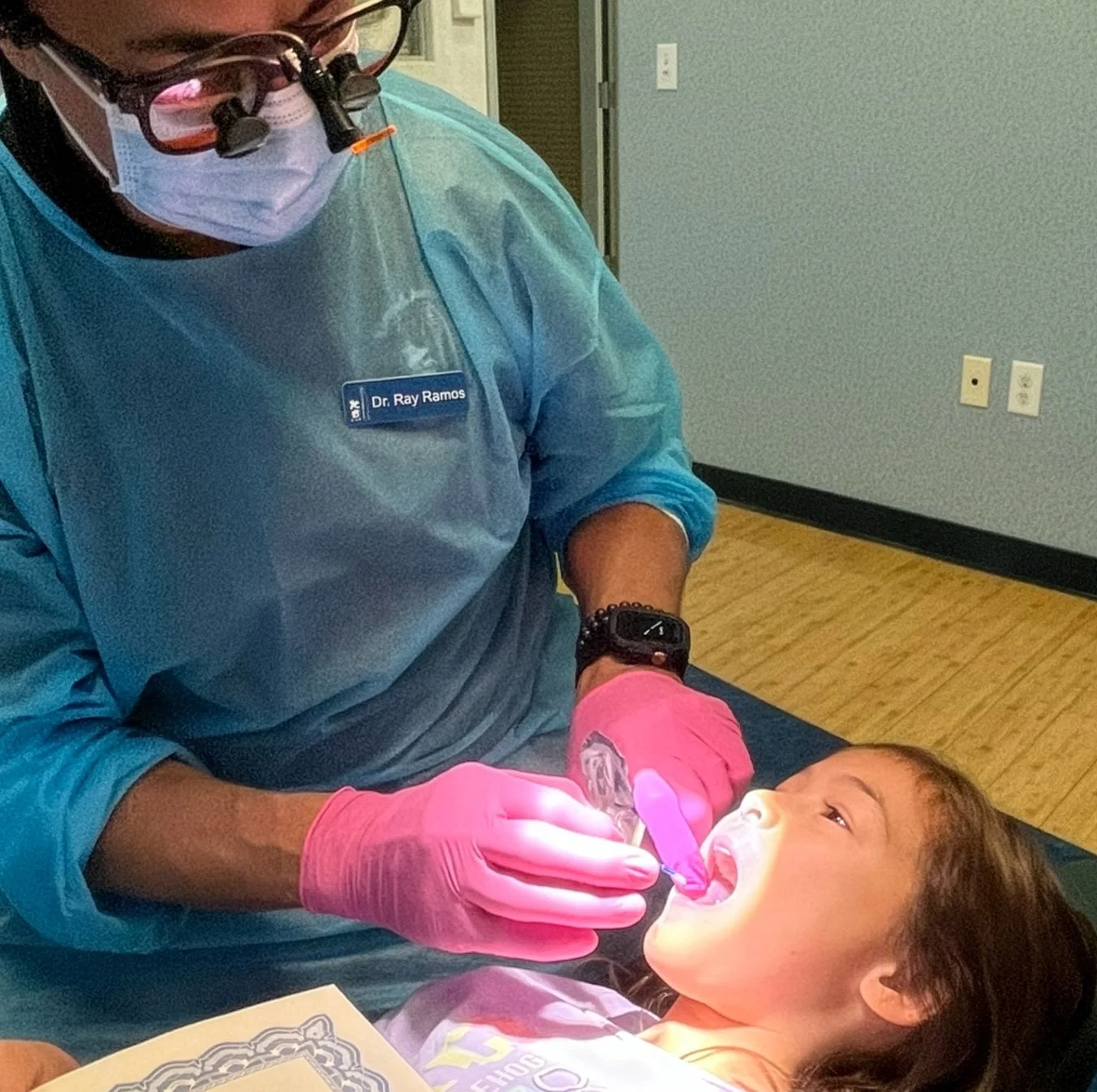 Dr. Ray cleaning a young girl's teeth in the dental office