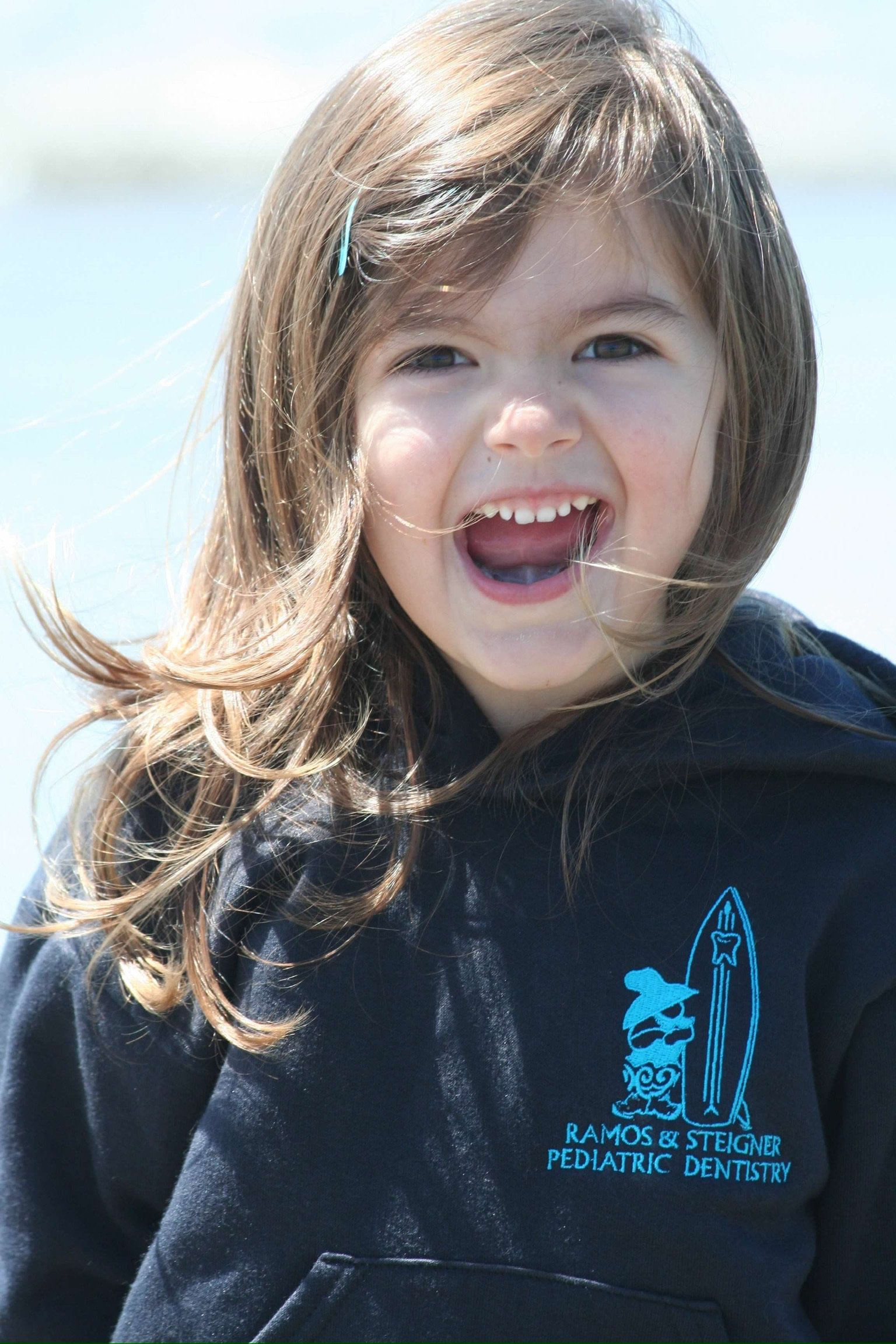 young girl smiling for the camera outdoors