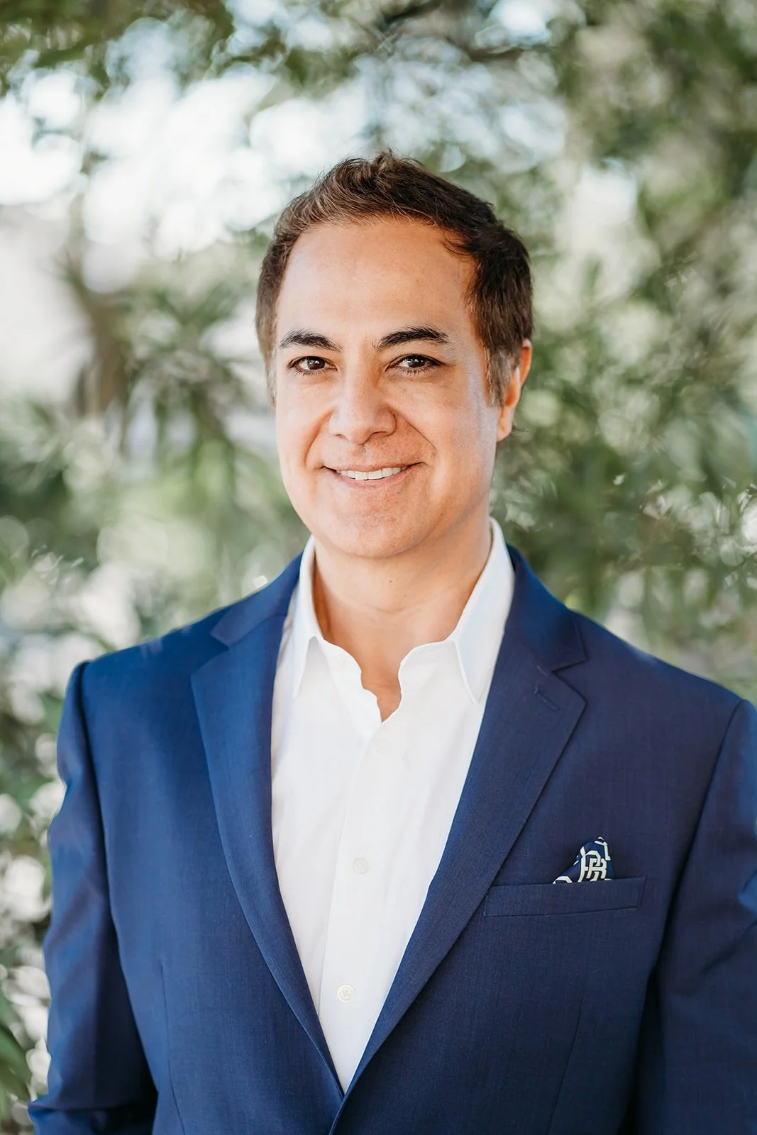 Dr. Ray Ramos, pediatric dentist, smiling in a suit