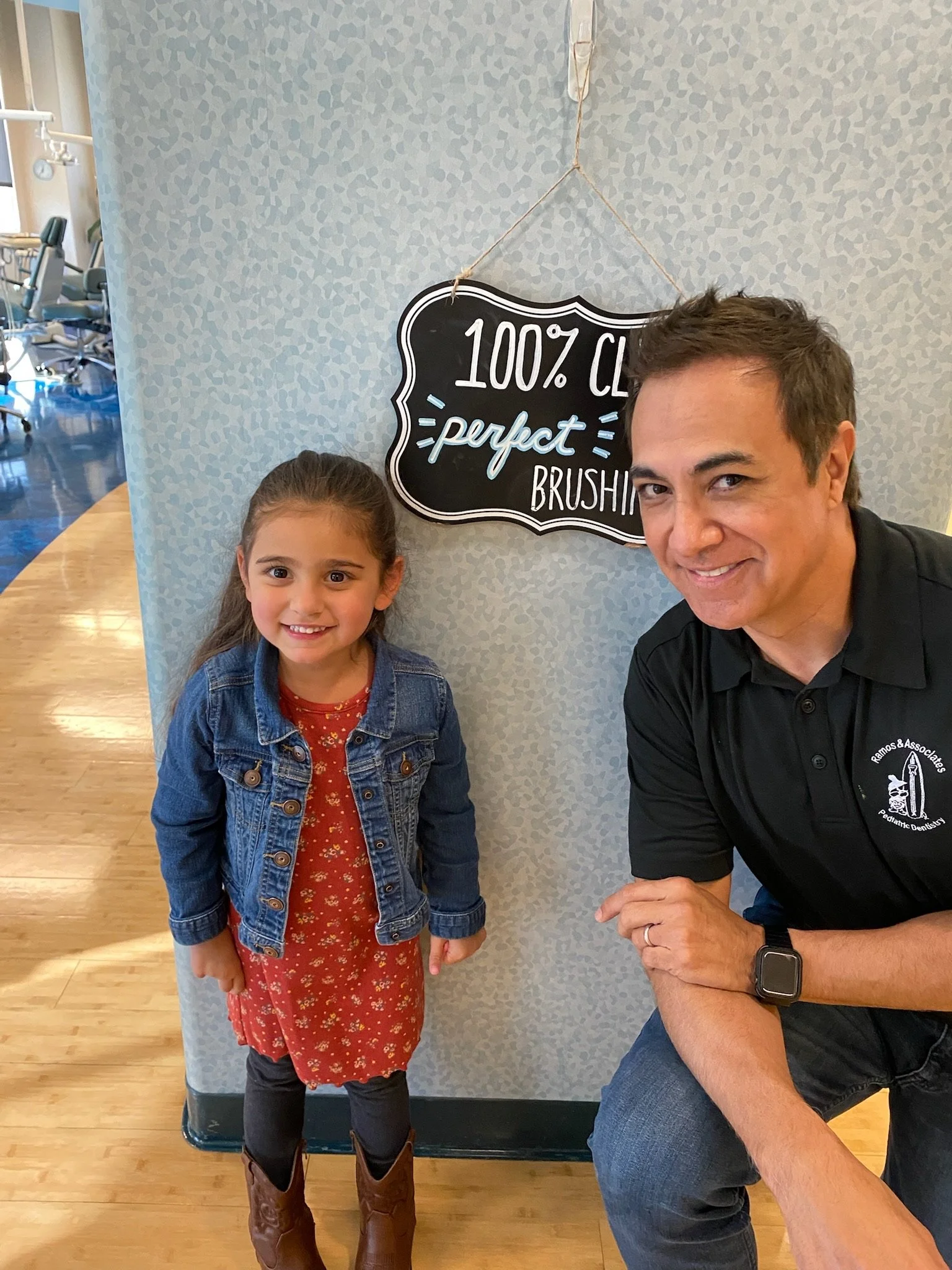 Dr. Ray posing with child during a preventative care visit in the office
