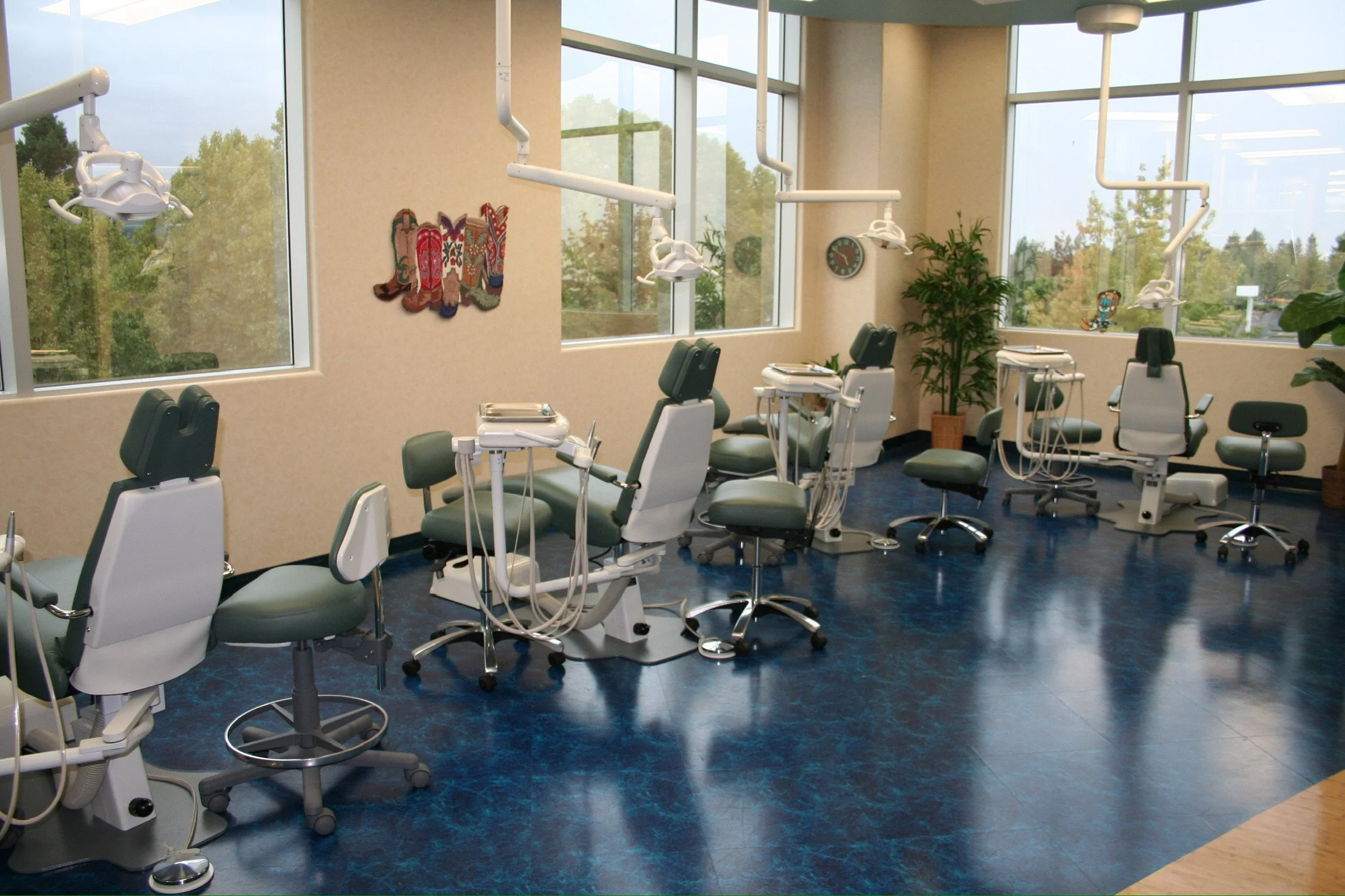 Pediatric dental treatment room with multiple dental chairs and large windows