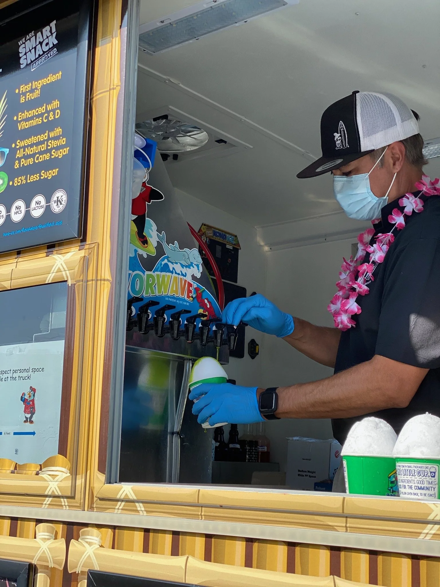 Dr. Ray wearing blue gloves dispensing a frozen treat from a truck window