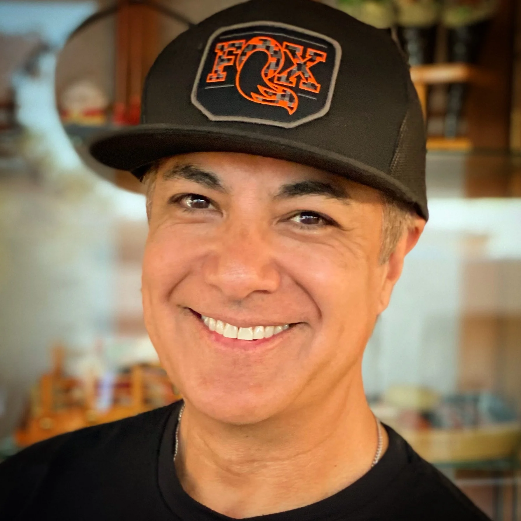 Dr. Ray Ramos, board-certified pediatric dentist, smiling in his dental office