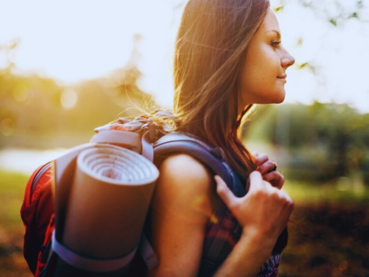 A Woman looks brightly into the future, prepared with her backpack