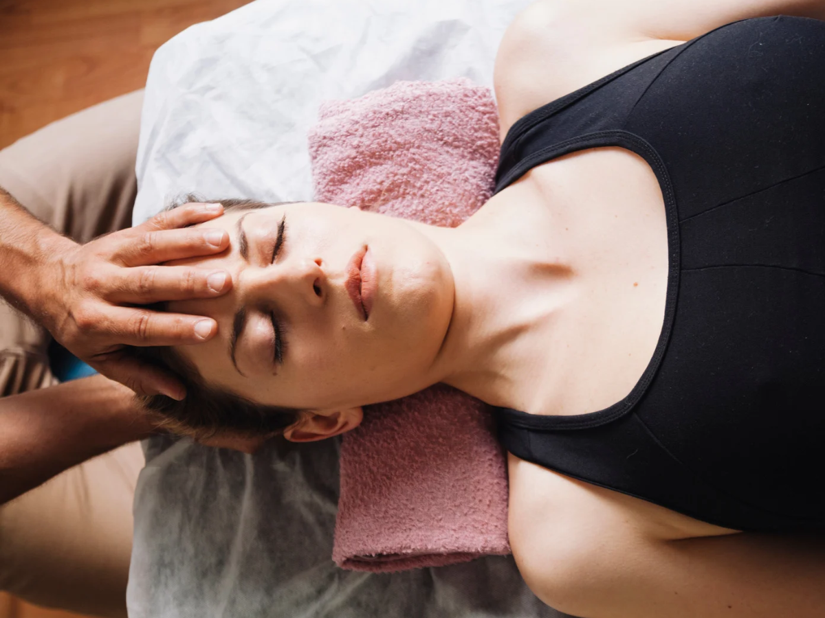 A woman relaxes on a Reiki table receiving Reiki