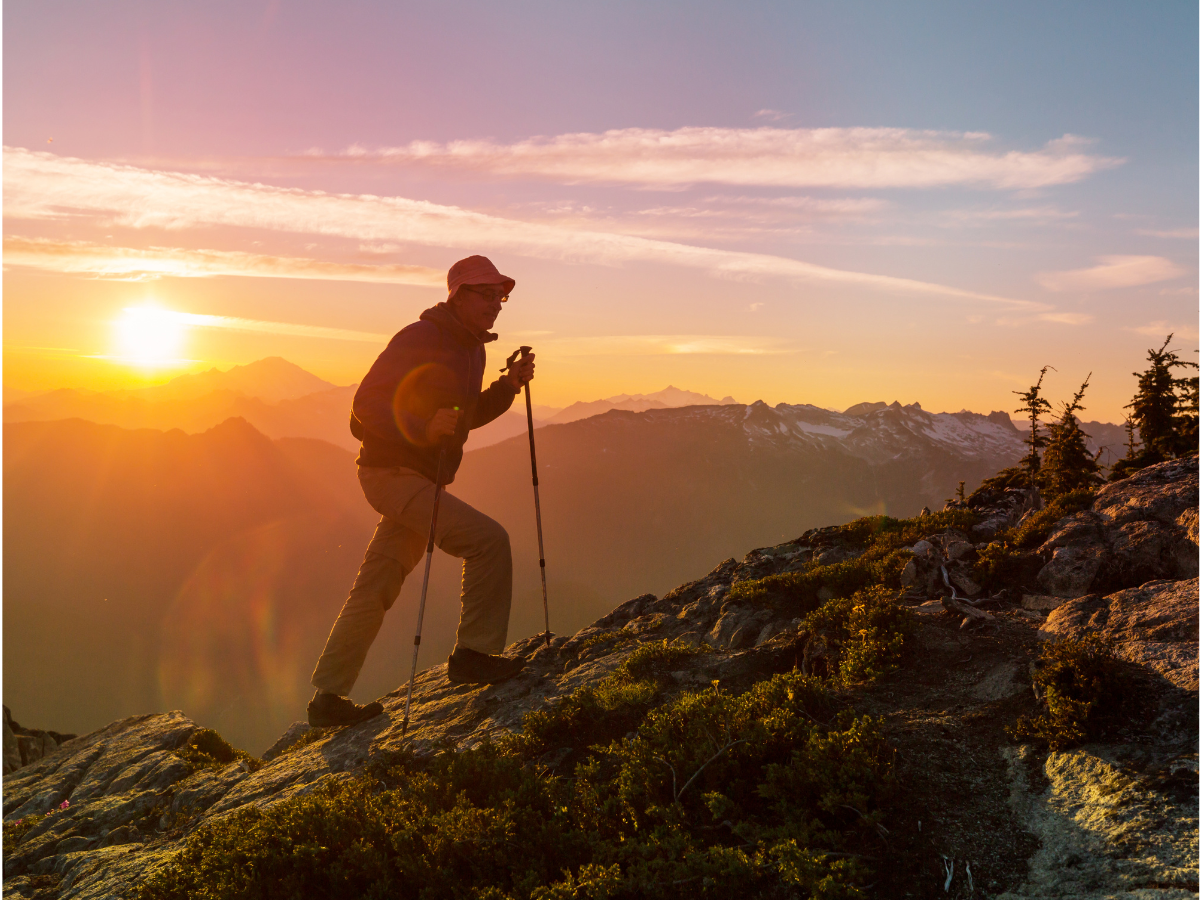 A man climbs a mountain at sunrise