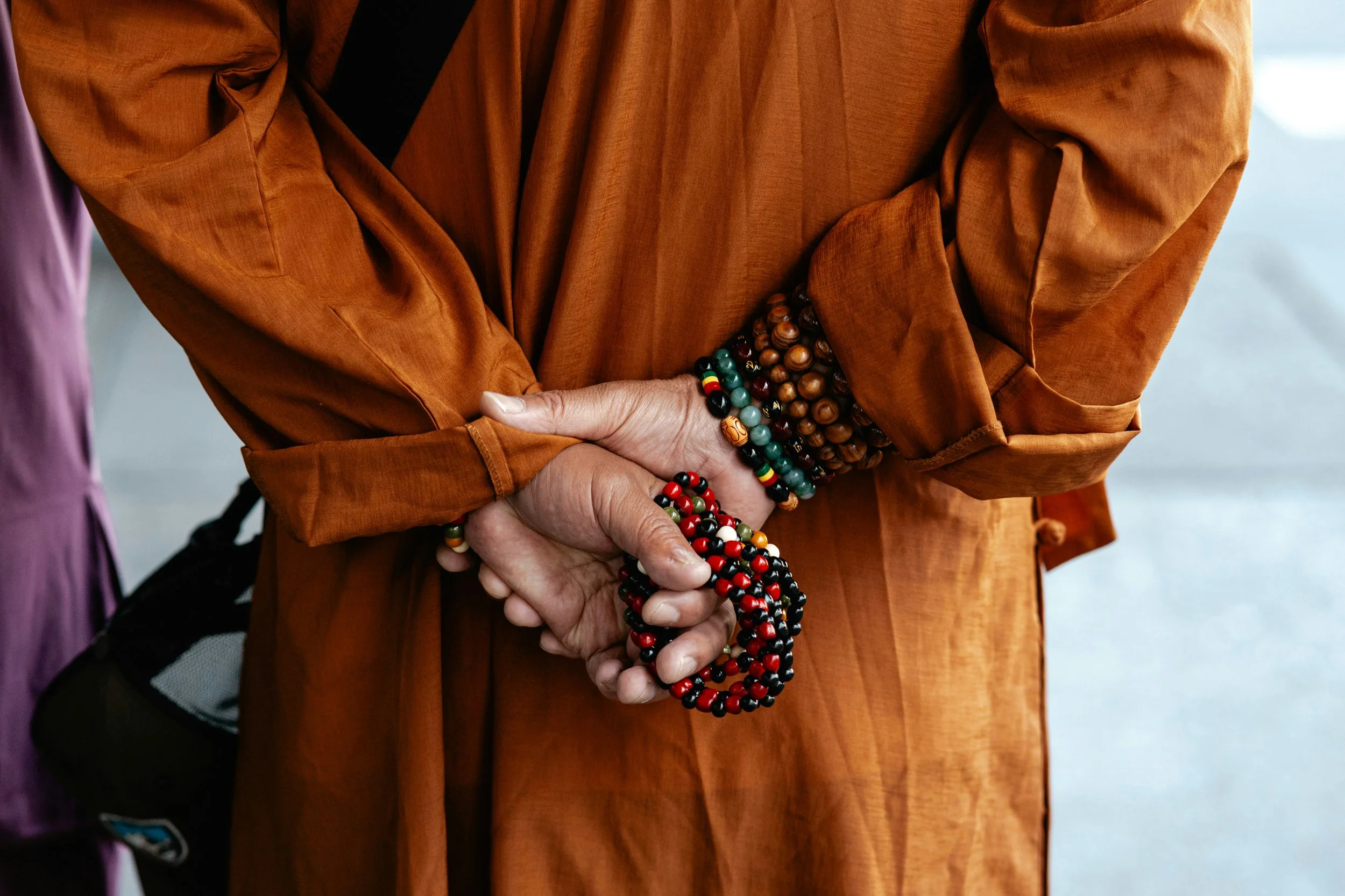 A close up of hands holding mala prayer beads