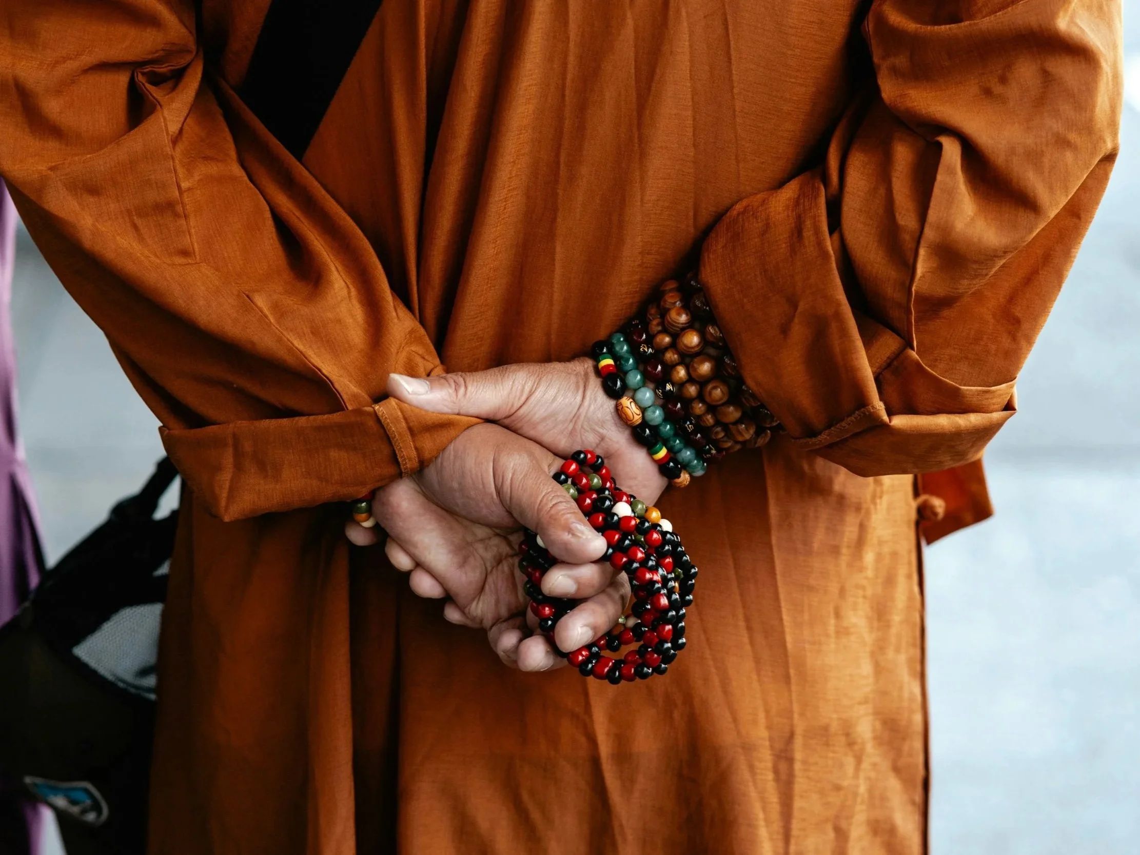 A person holds mala prayer beads