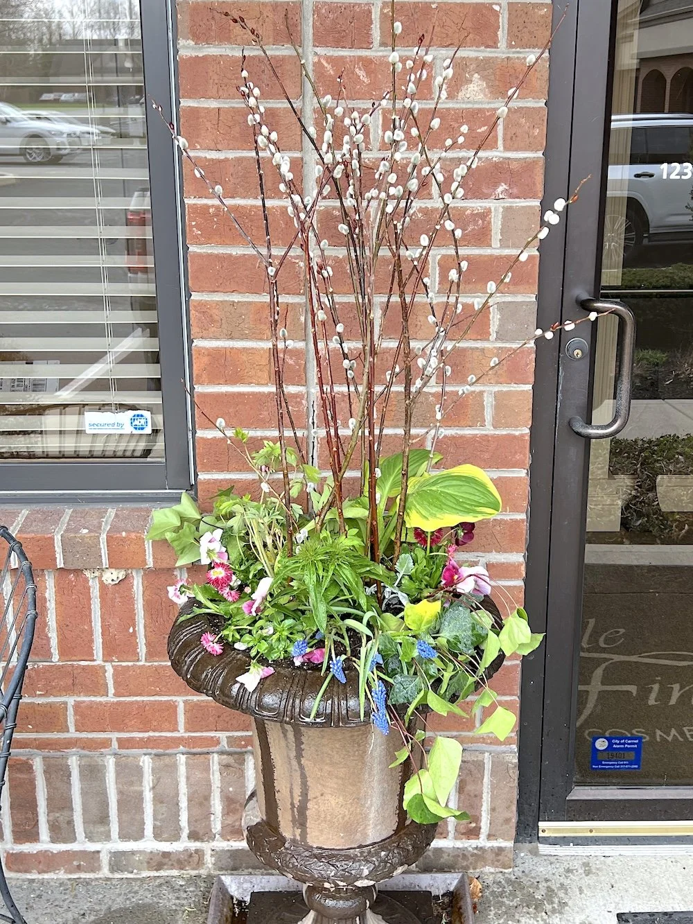 Fresh, vibrant spring planters overflowing with seasonal blooms and lush greenery at Michele Finley in Carmel, IN. These professionally designed outdoor planters feature a mix of colorful flowers, textured foliage, and natural elements that enhance t