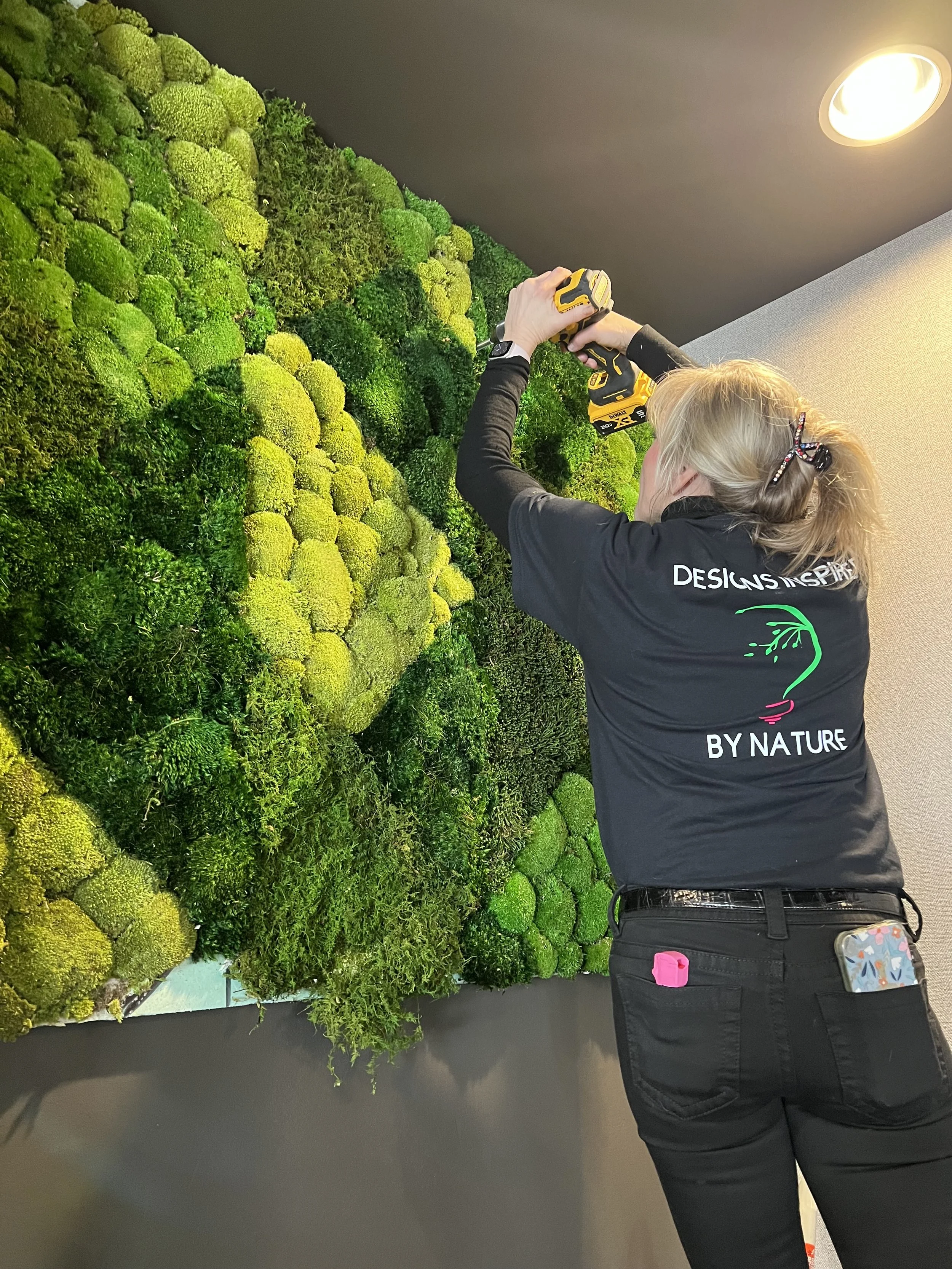 Stephanie Carlson, owner of Naturspire, installing a moss wall at Vide, a Cunningham Restaurant, in Indianapolis, IN