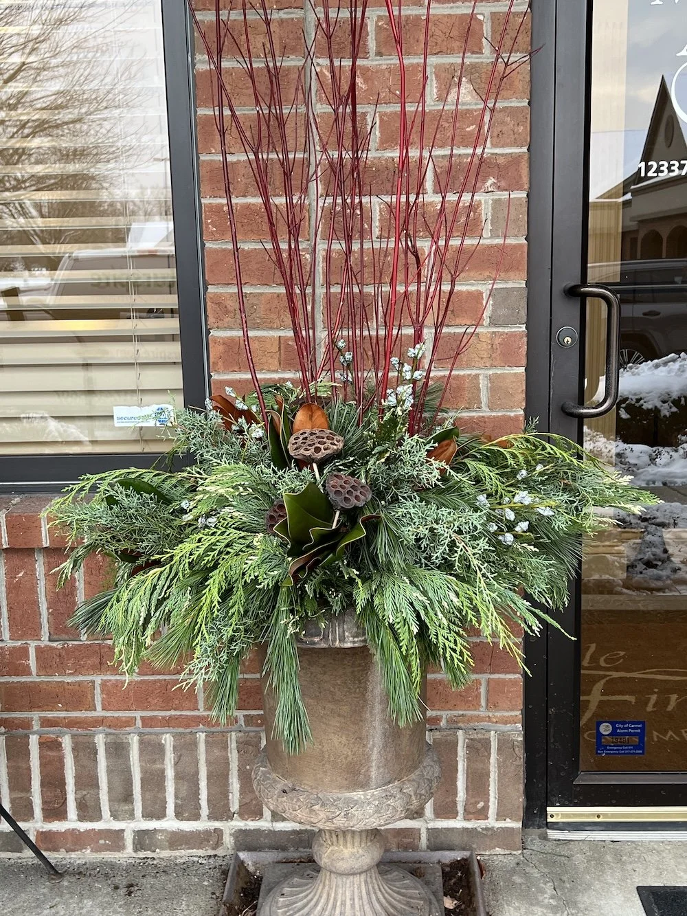 Neutral and red accents in holiday porch pots.