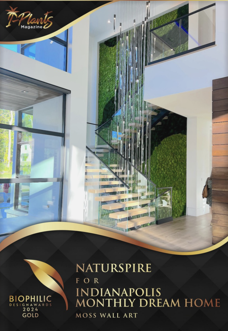 Modern interior staircase with glass railing and moss wall art in a spacious home, featuring natural light and greenery.