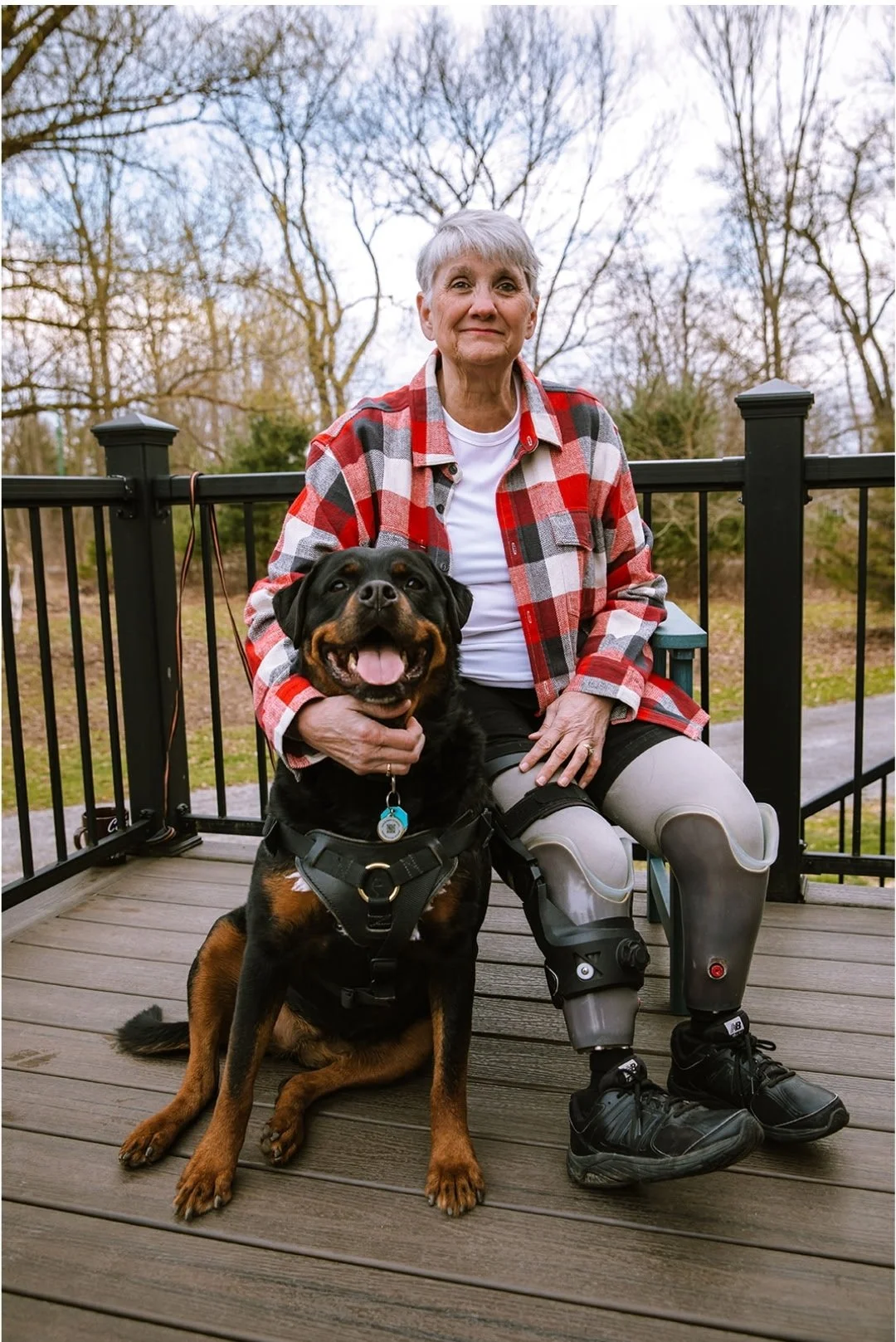 A woman with prosthetic legs sitting with her service dog