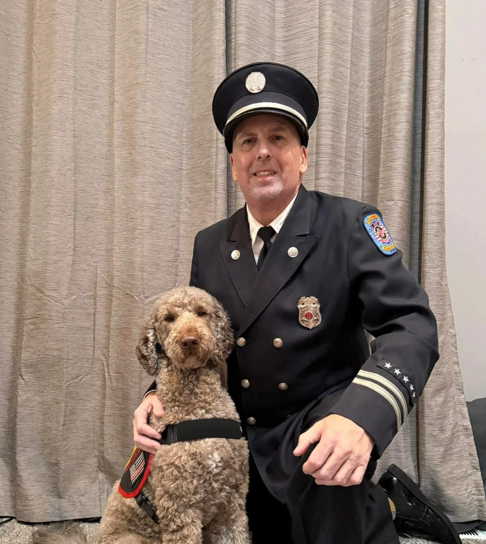 A veteran kneeling with his companion dog.