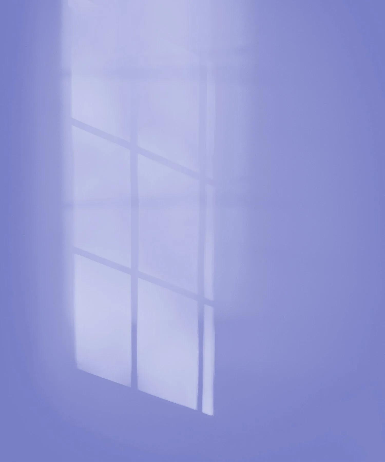 A window with sunlight casting a soft reflection on a blue wall.