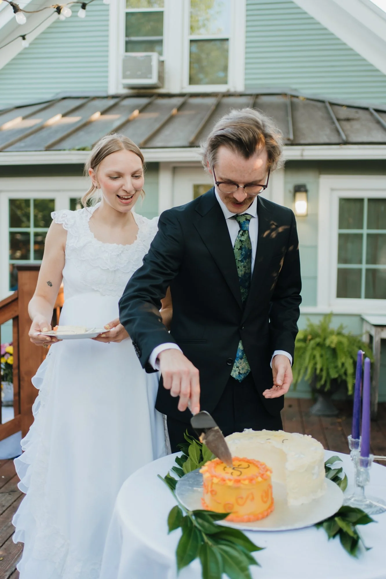 Hunter cuts the cake while Zoe smiles.