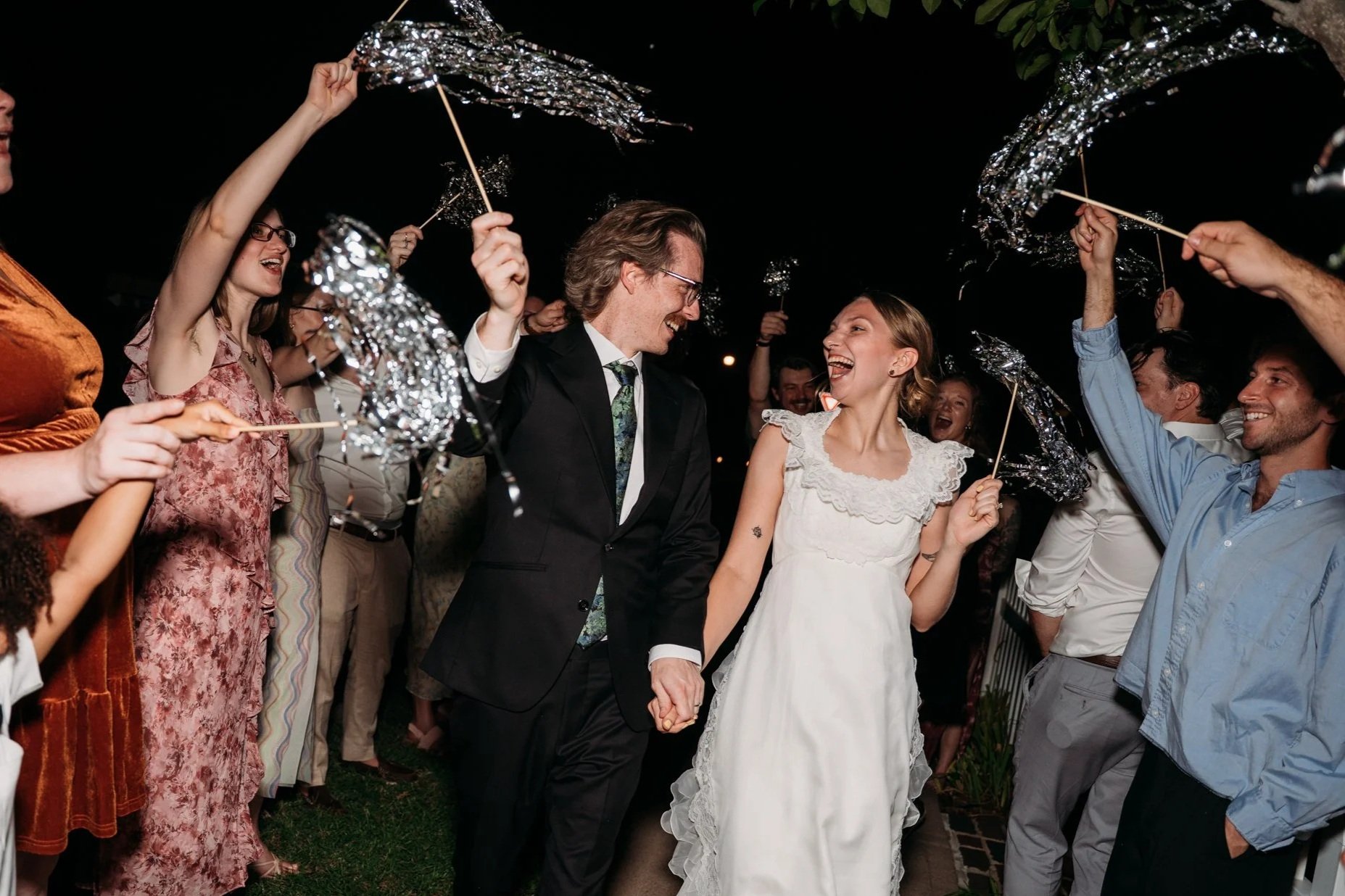 Guests wave tinsel wands as Zoe and Hunter leave.