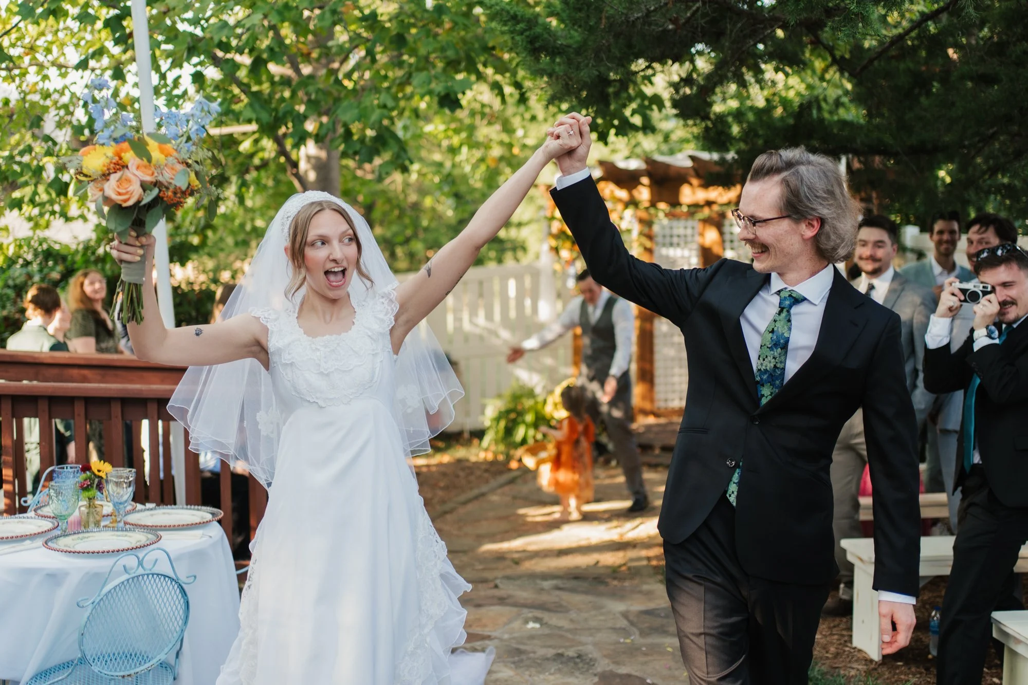 Zoe and Hunter walk back down the aisle with their hands in the air.