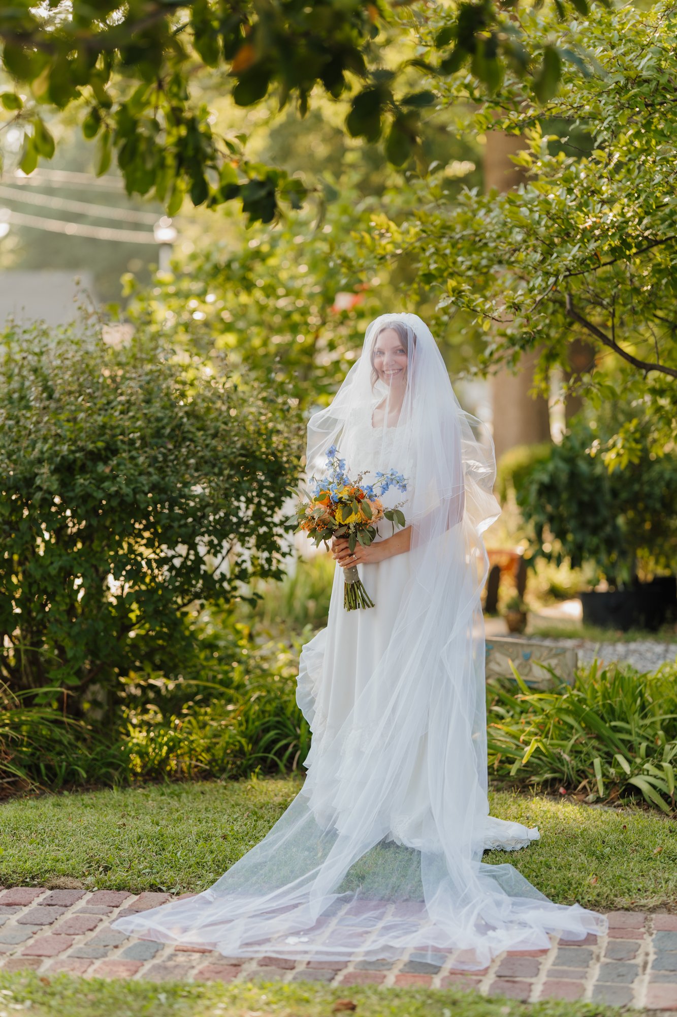 Zoe in her long veil in the front garden.