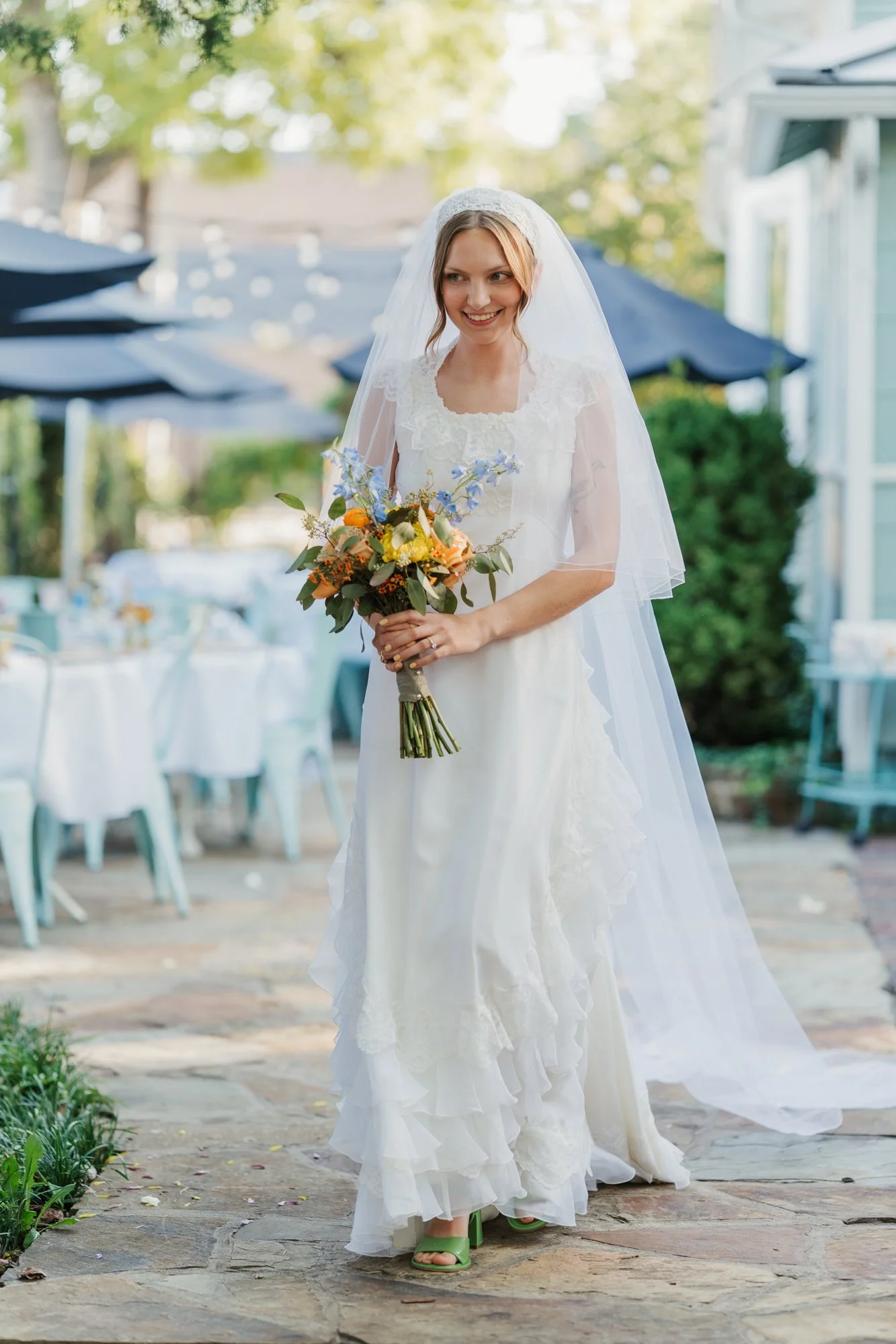 Zoe walks through the backyard of The Vintage House with her bouquet.