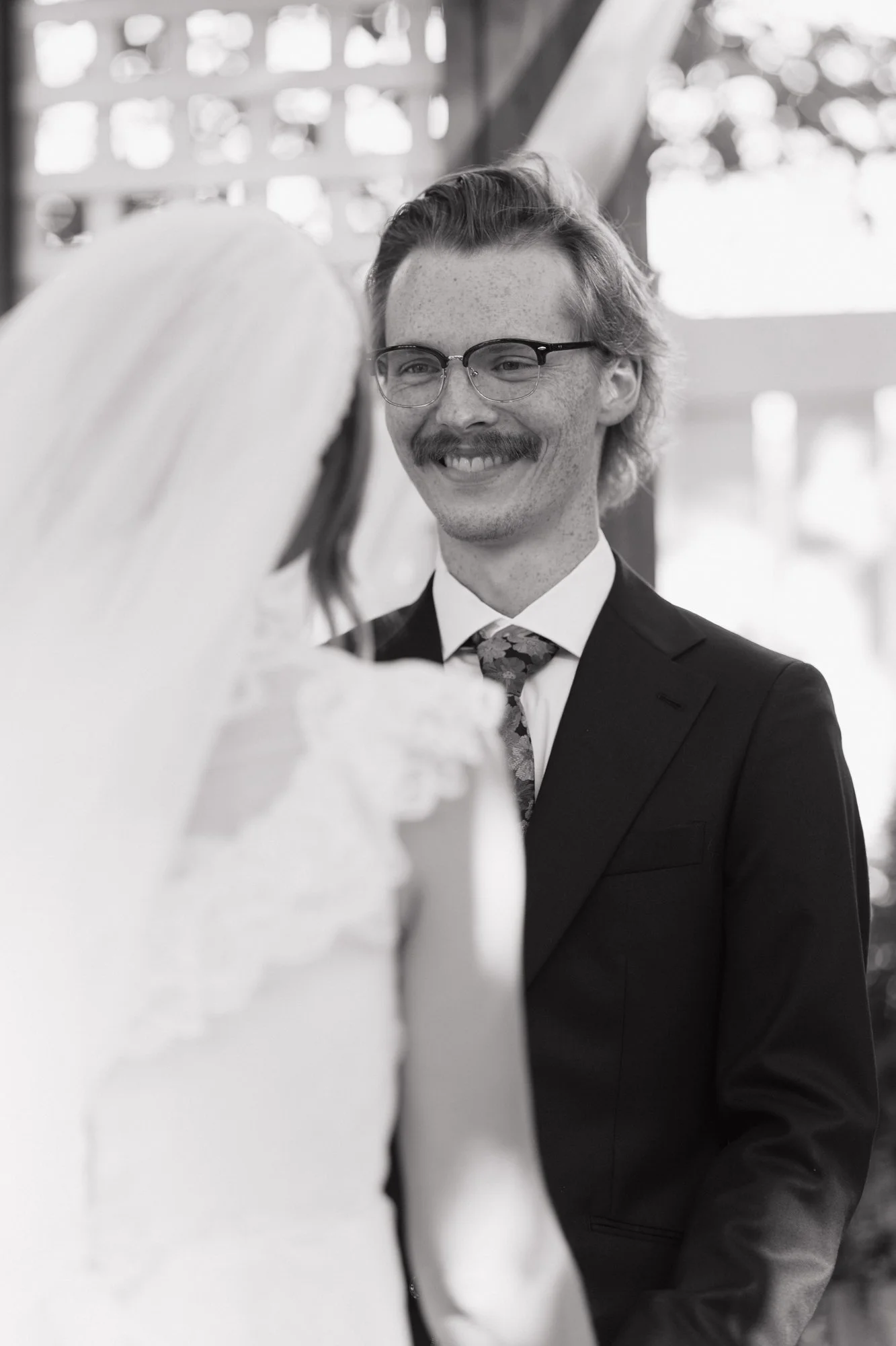Hunter grins at Zoe during the ceremony, in black and white.