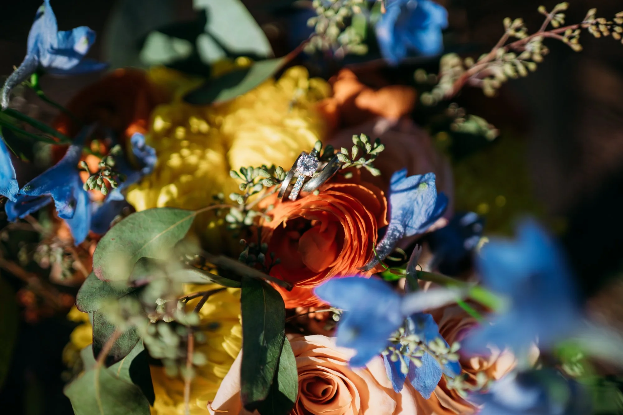 Close up of the bouquet with the wedding rings tucked in the flowers.