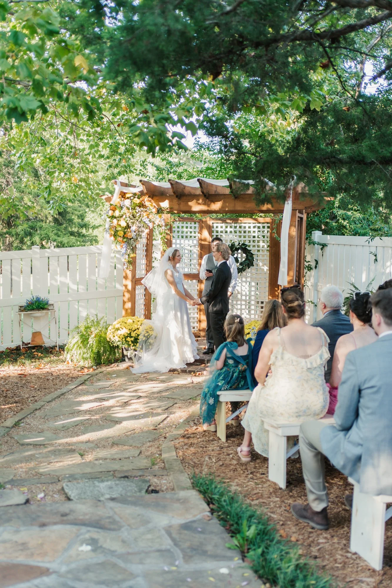 Guests watch Zoe and Hunter's intimate backyard wedding ceremony in Overland Park.