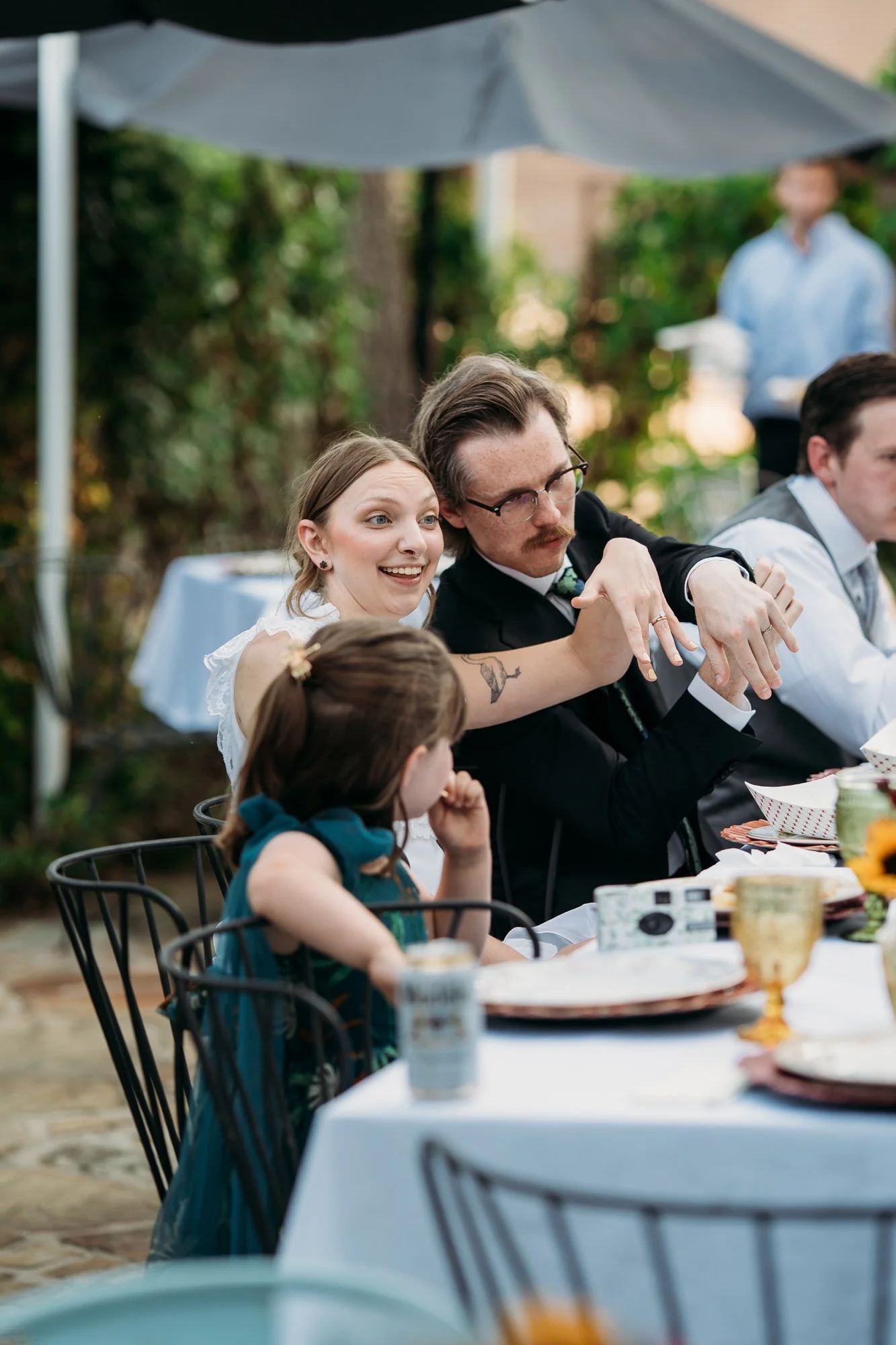 Zoe and Hunter show their rings to a little guest at the table.