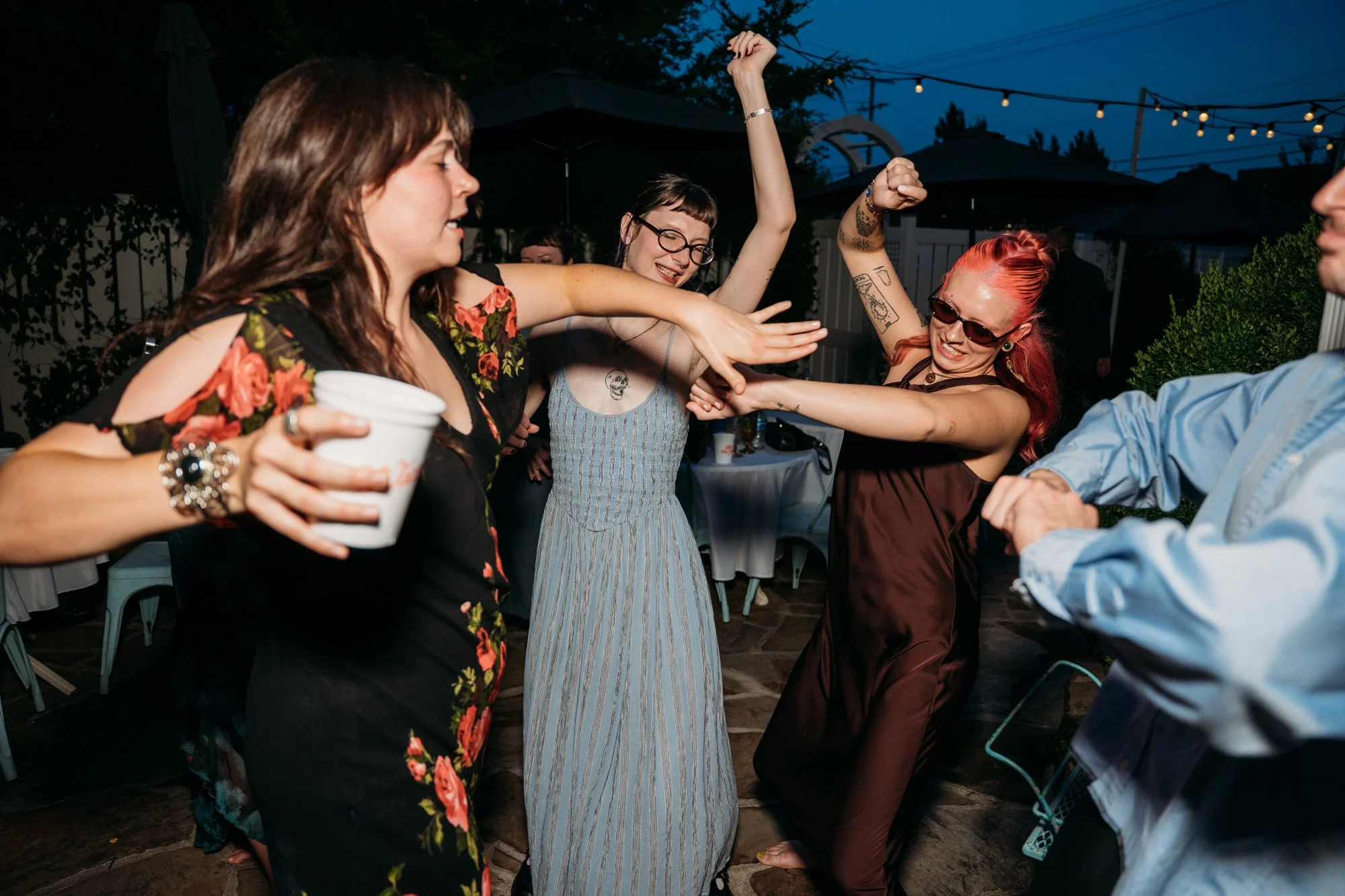Guests dance on the patio at night.
