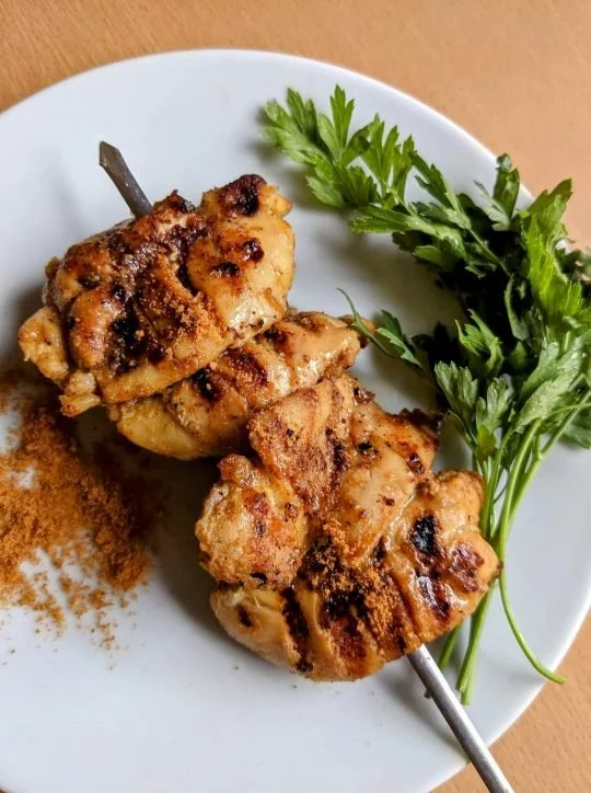 Chicken suya on a plate, skewered to perfection