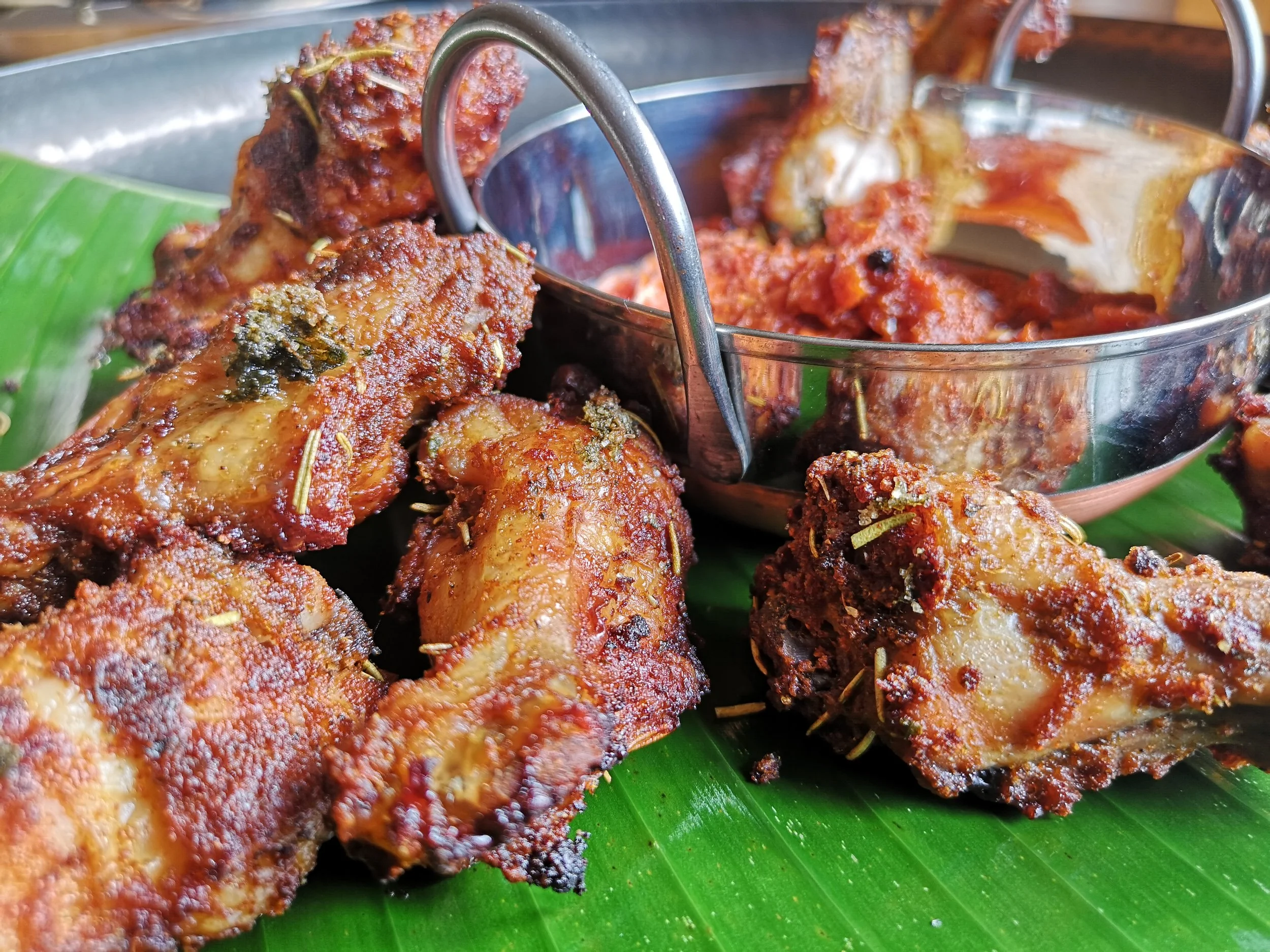 Chicken wings with wild rosemary, presented on banana leaves