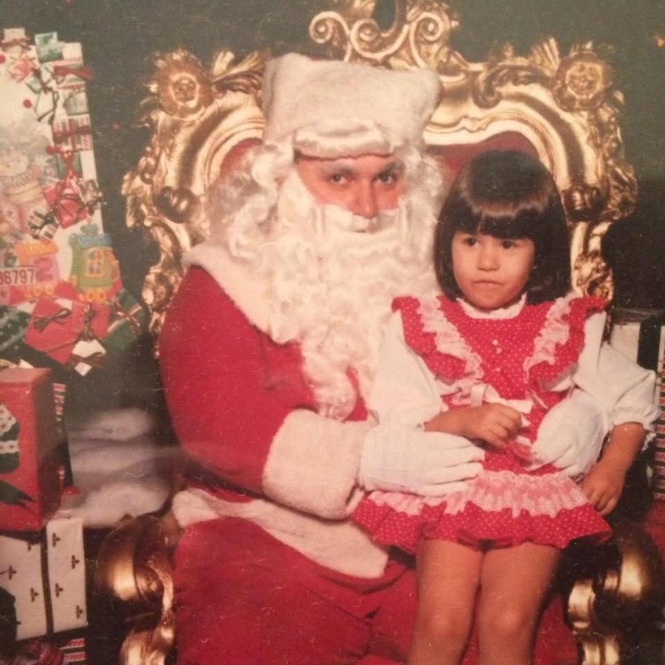 Little girl sitting on santas lap in vintage photo