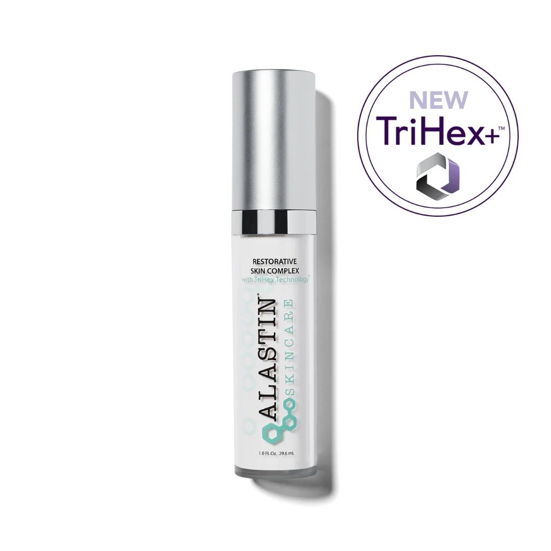 A skincare product called Alastin Restorative Skin Complex with TriHex Technology, shown in a white bottle with a silver cap. There is a purple and black circular label indicating it is a new TriHex product.
